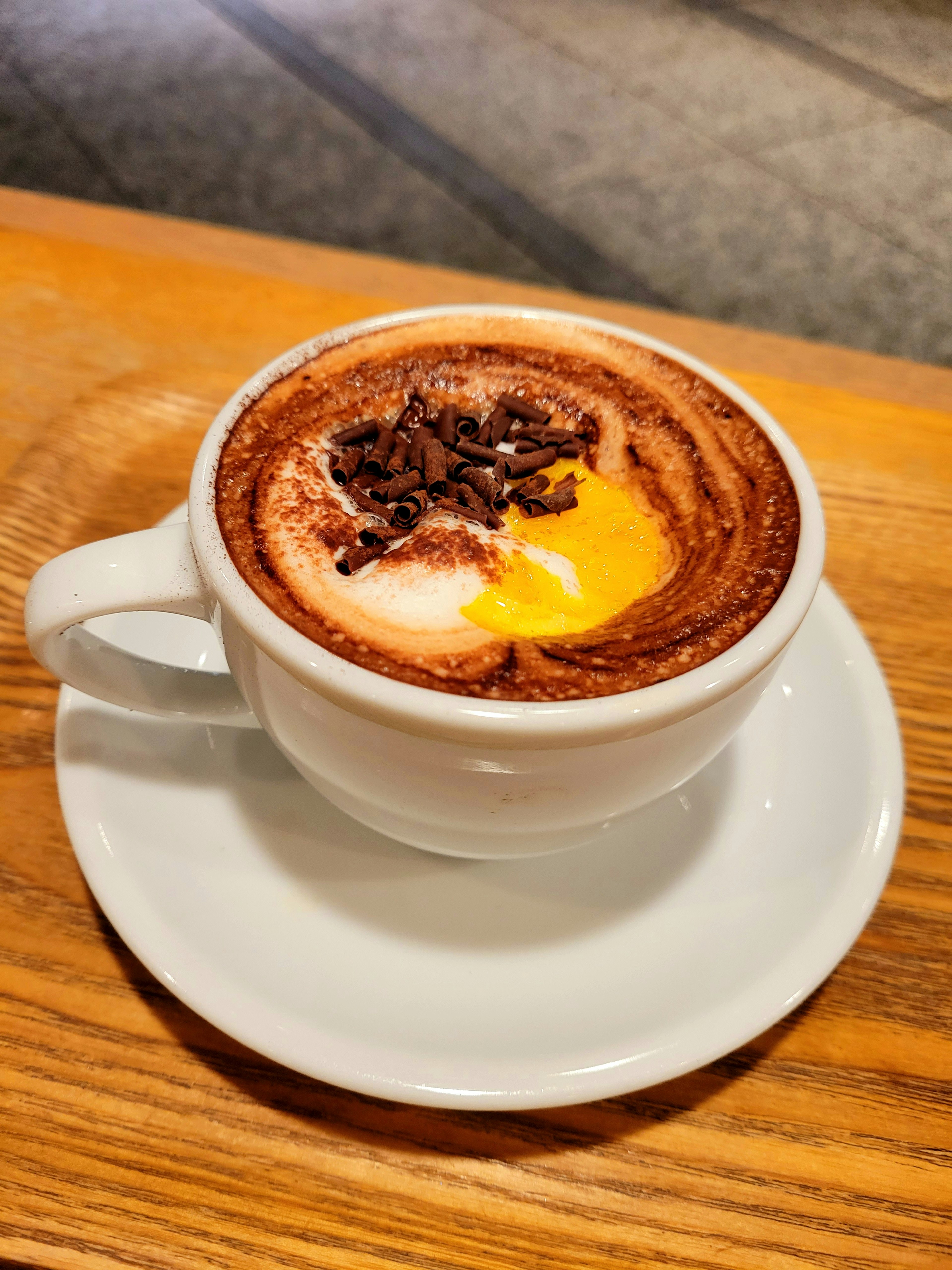 Creamy chocolate drink topped with egg yolk and chocolate flakes