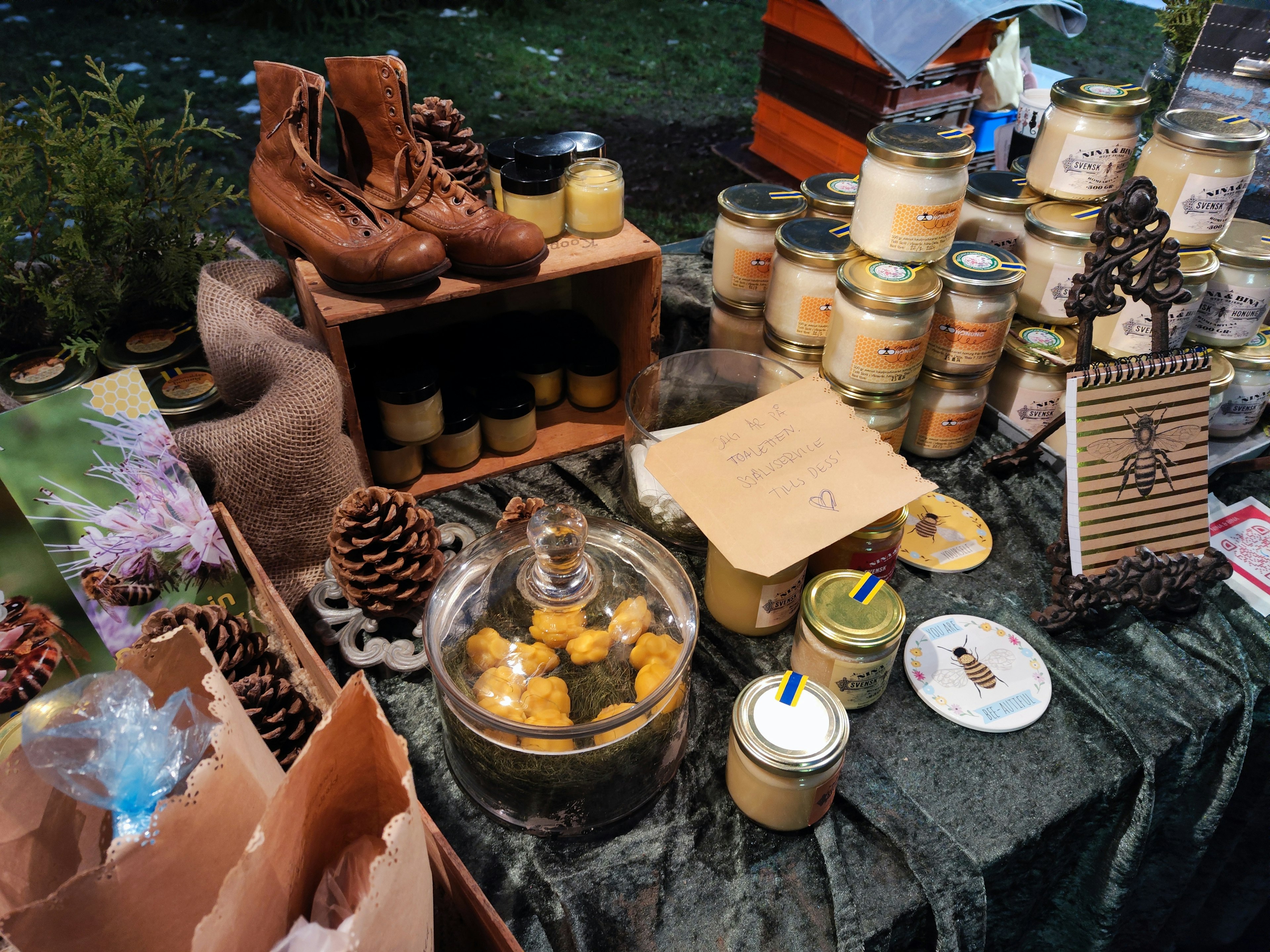 Outdoor market display featuring candles and pine cones