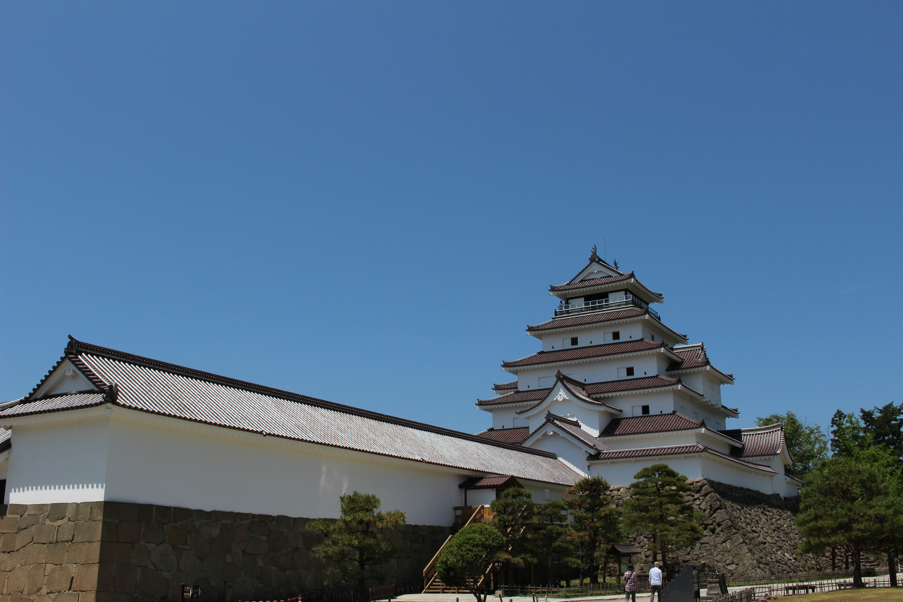 A beautiful castle soaring under a blue sky with surrounding greenery