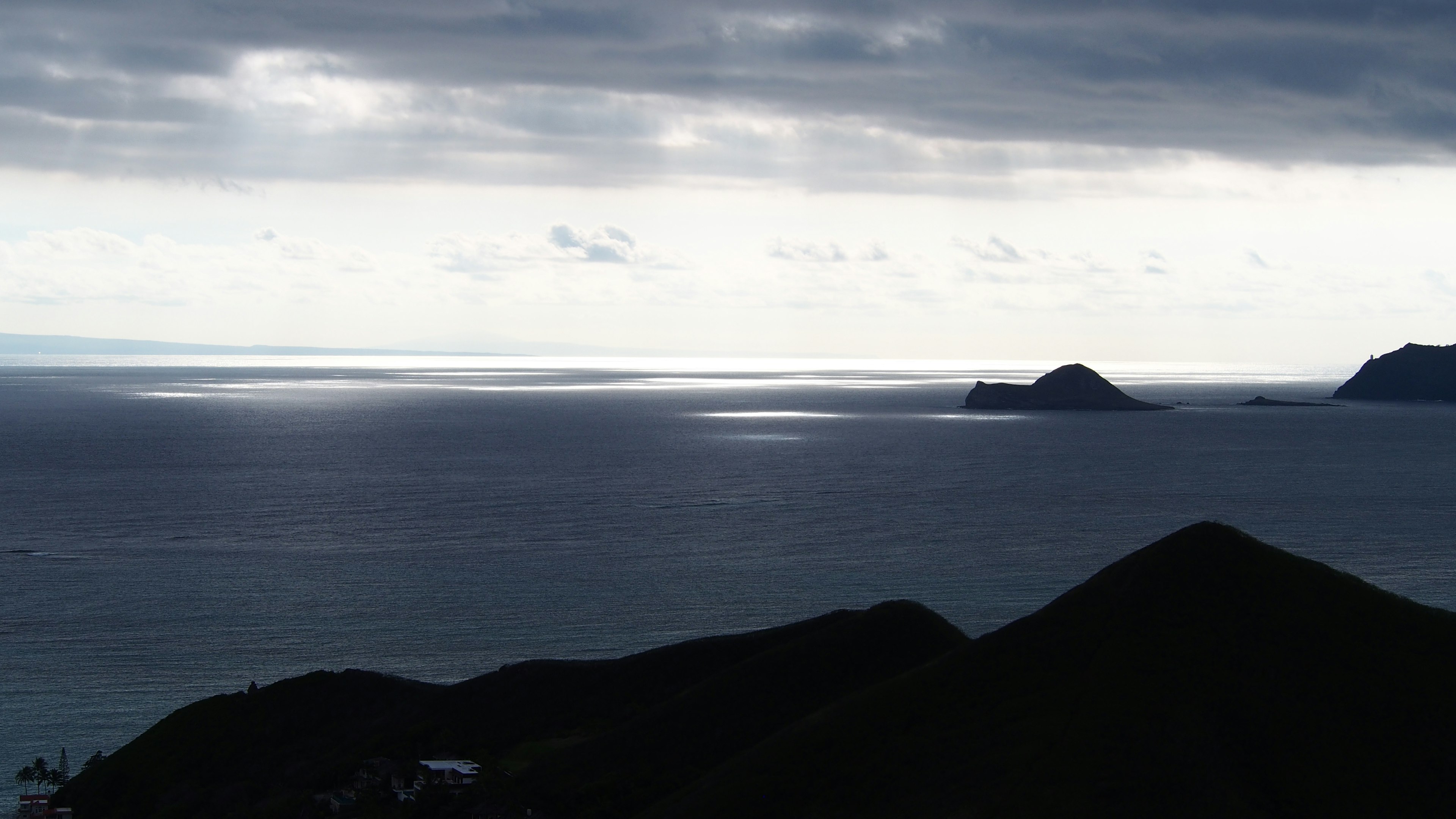 Paysage maritime dramatique avec des nuages sombres et des îles lointaines