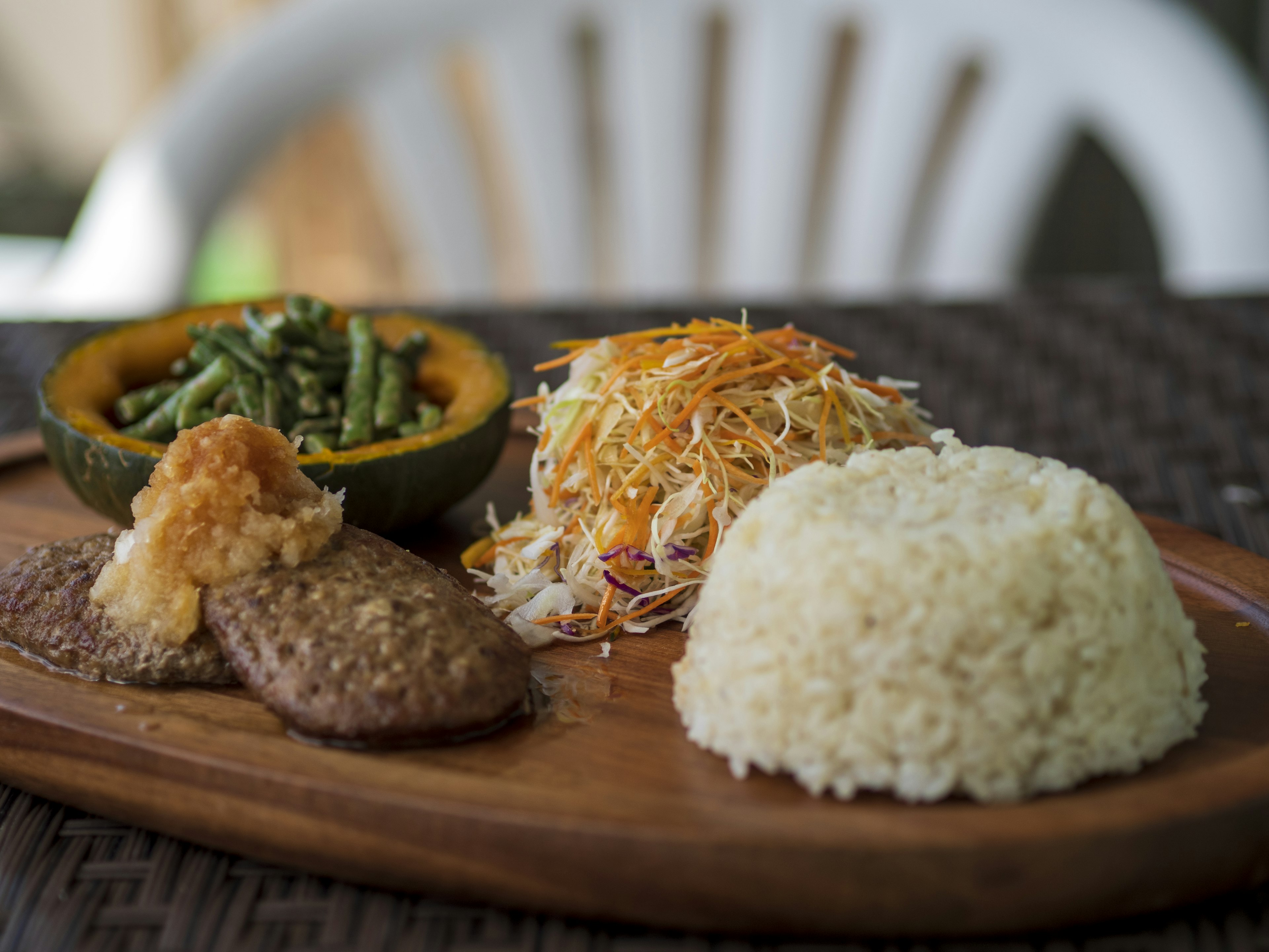 Piring yang menyajikan nasi, sayuran serut, dan daging bersama dengan labu