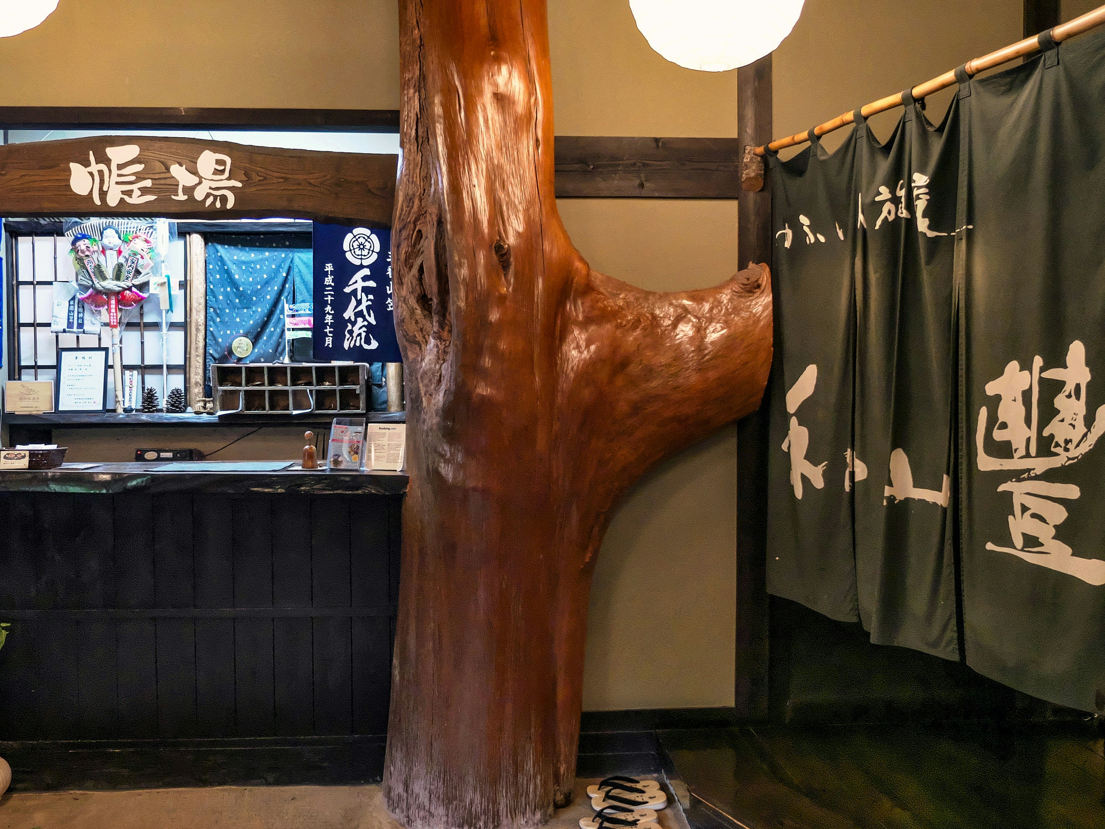 Reception area of a traditional Japanese inn featuring a large wooden pillar