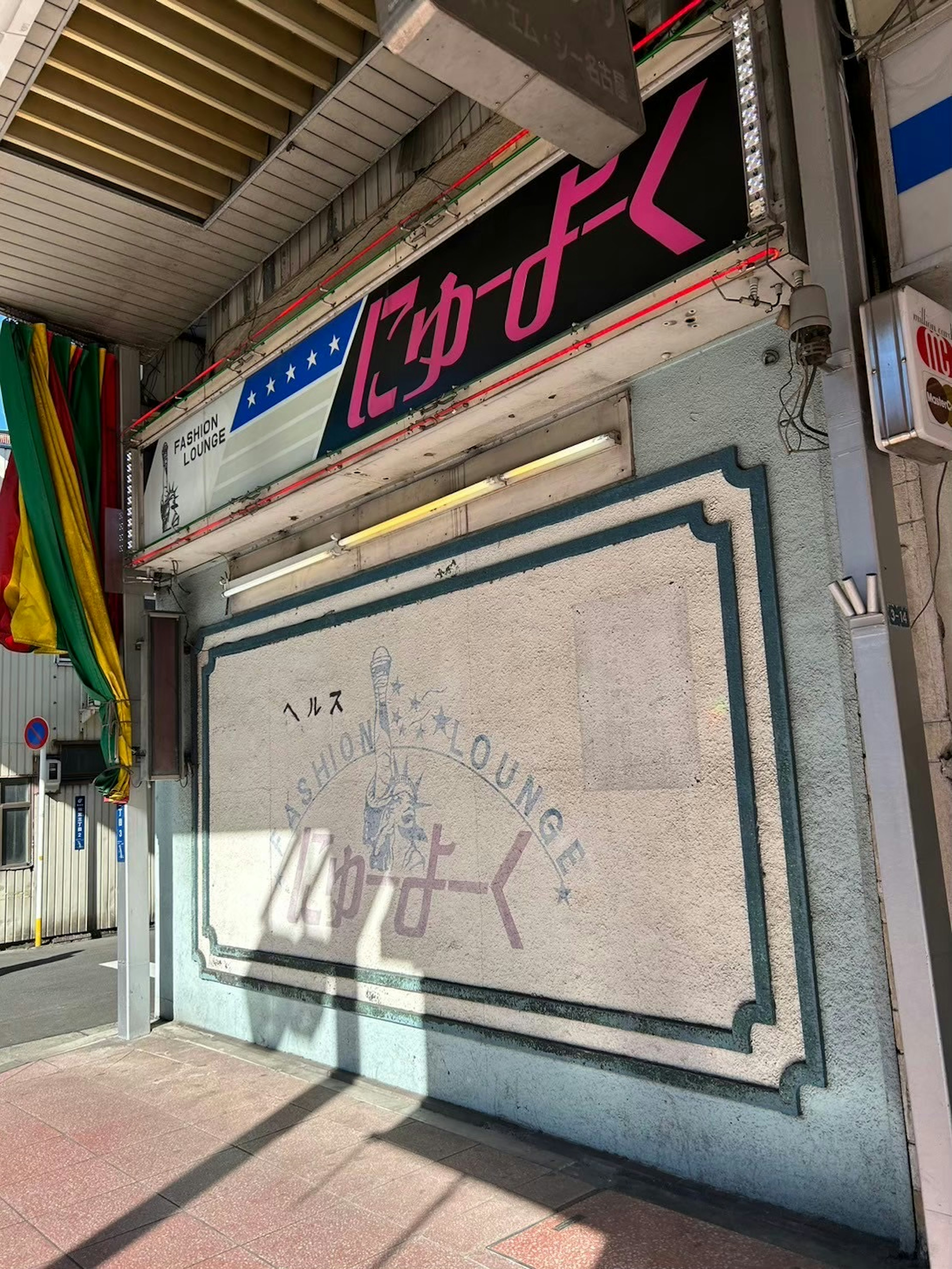 Extérieur d'un magasin avec un texte japonais sur un mur de couleur vive