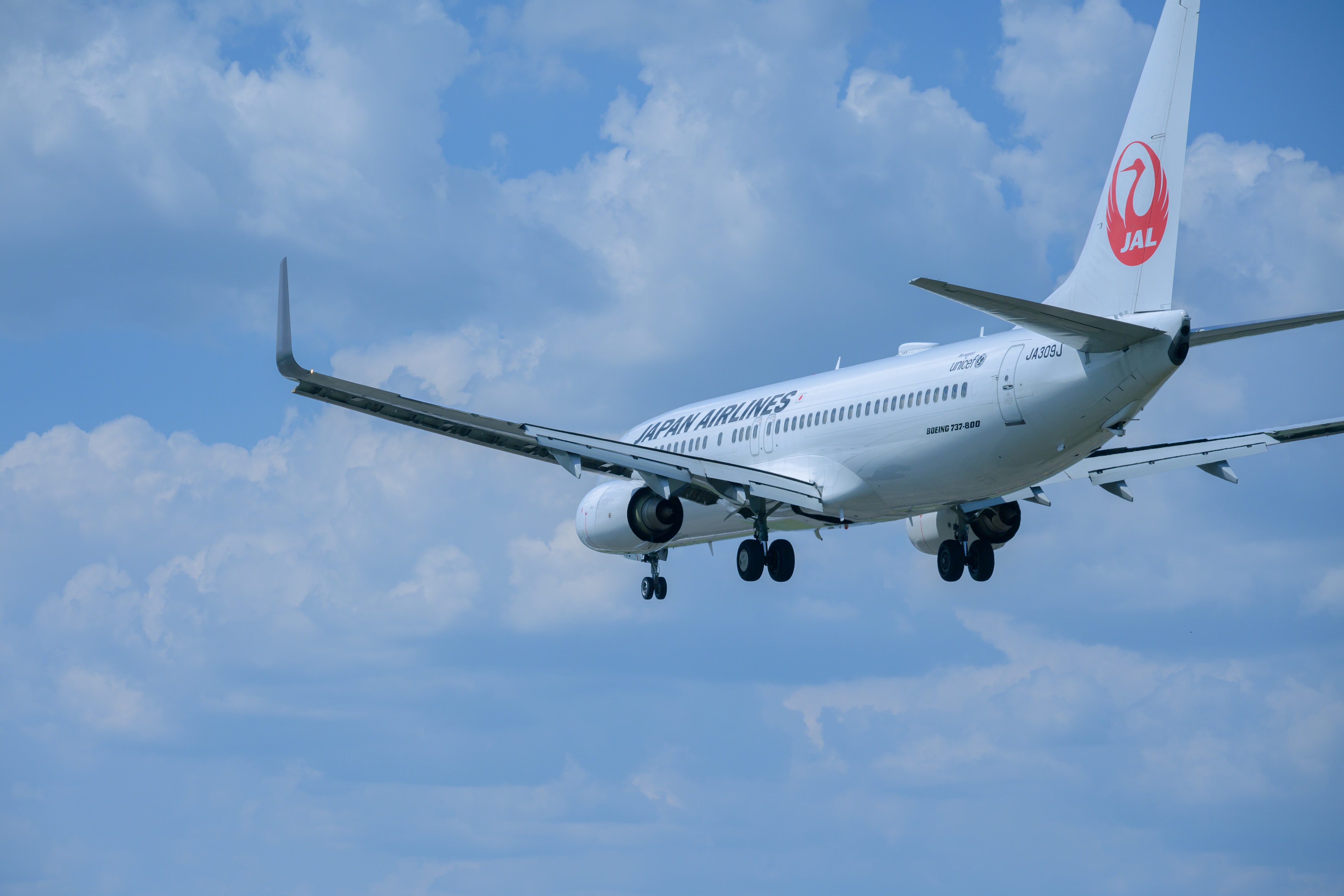 Pesawat Japan Airlines terbang di langit biru