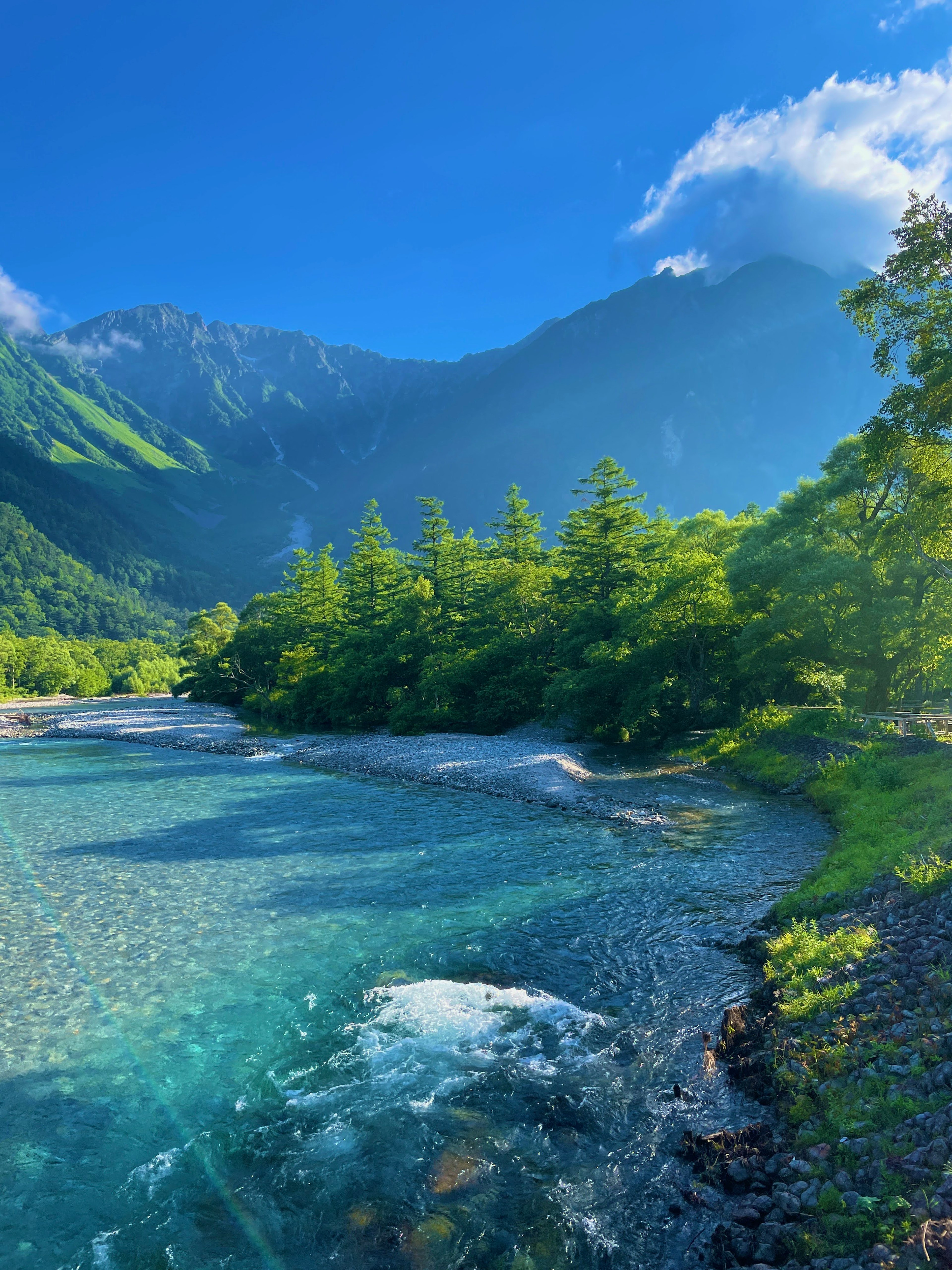 青い川と緑の木々に囲まれた山の風景