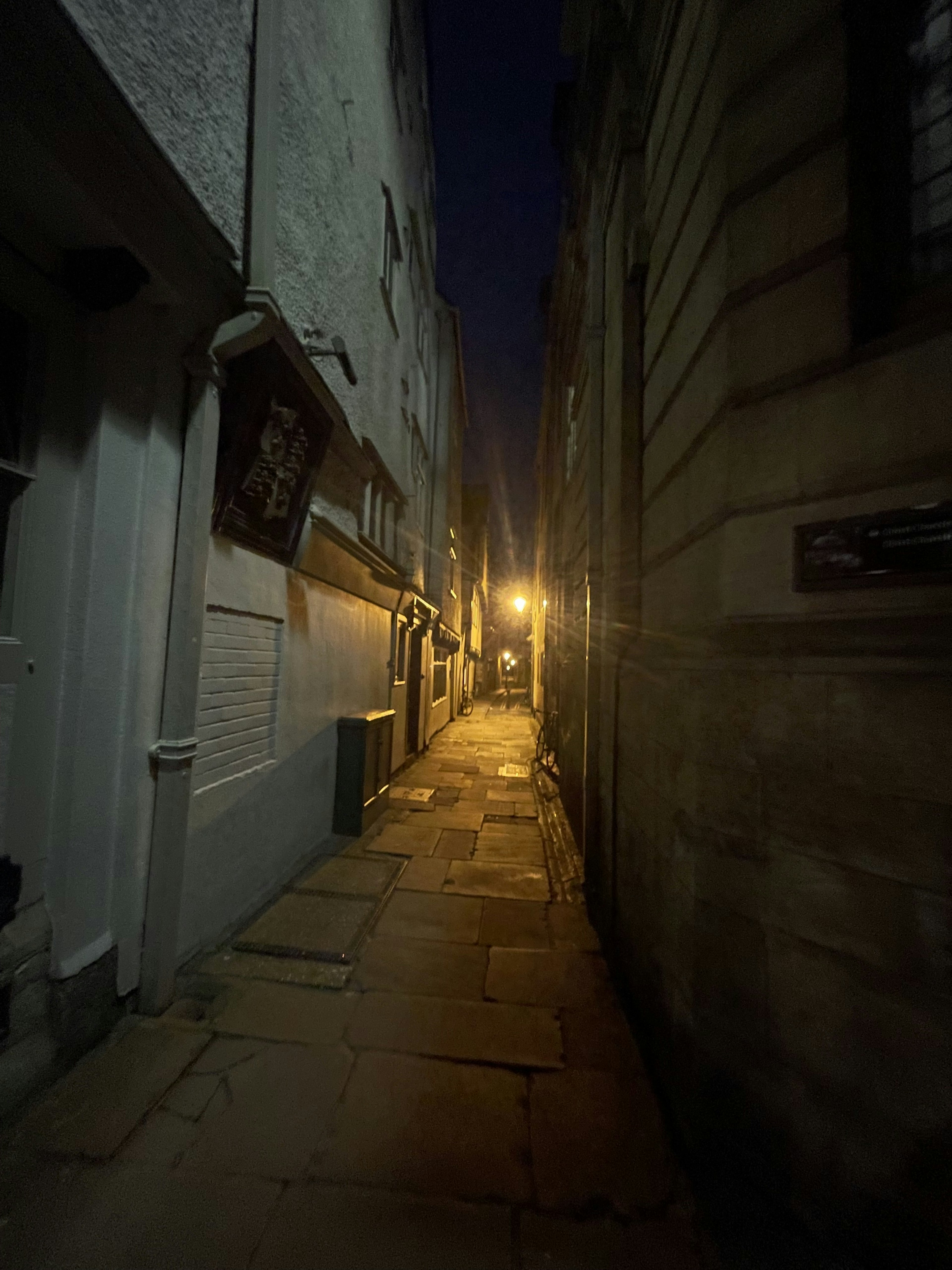 Enge Gasse bei Nacht mit einer hellen Straßenlaterne und alten Gebäuden