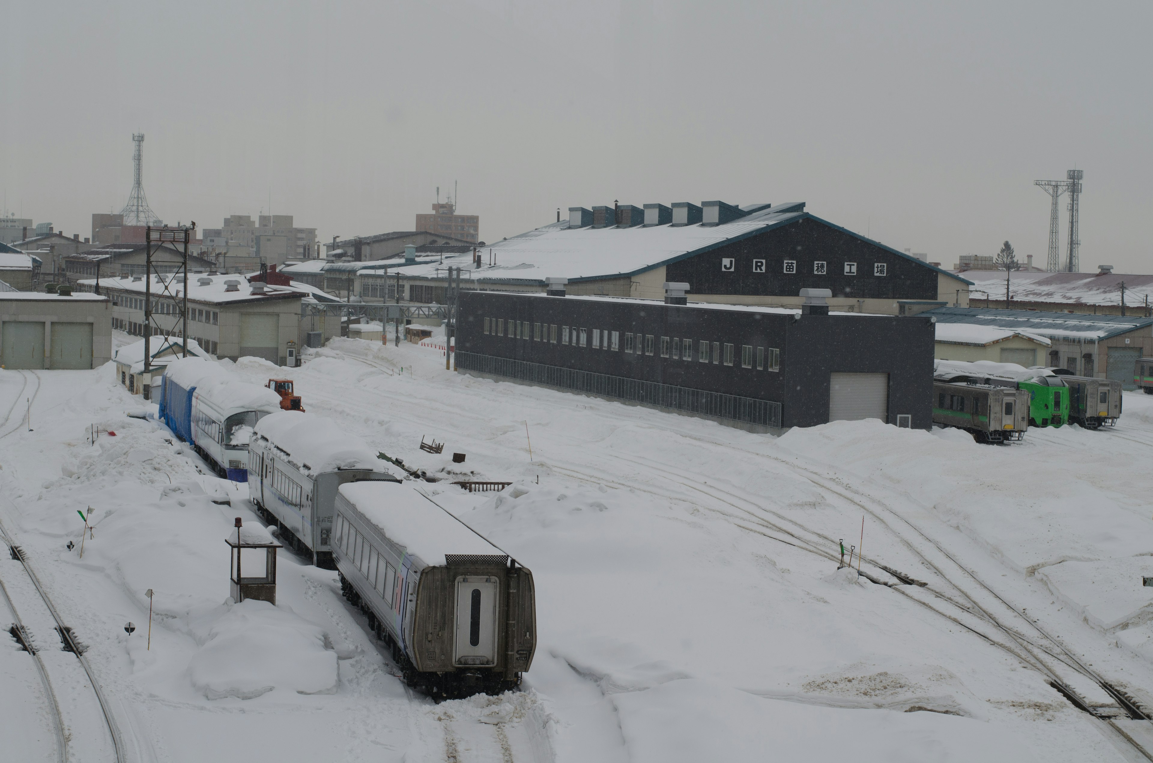 Snow-covered railway scene with warehouses