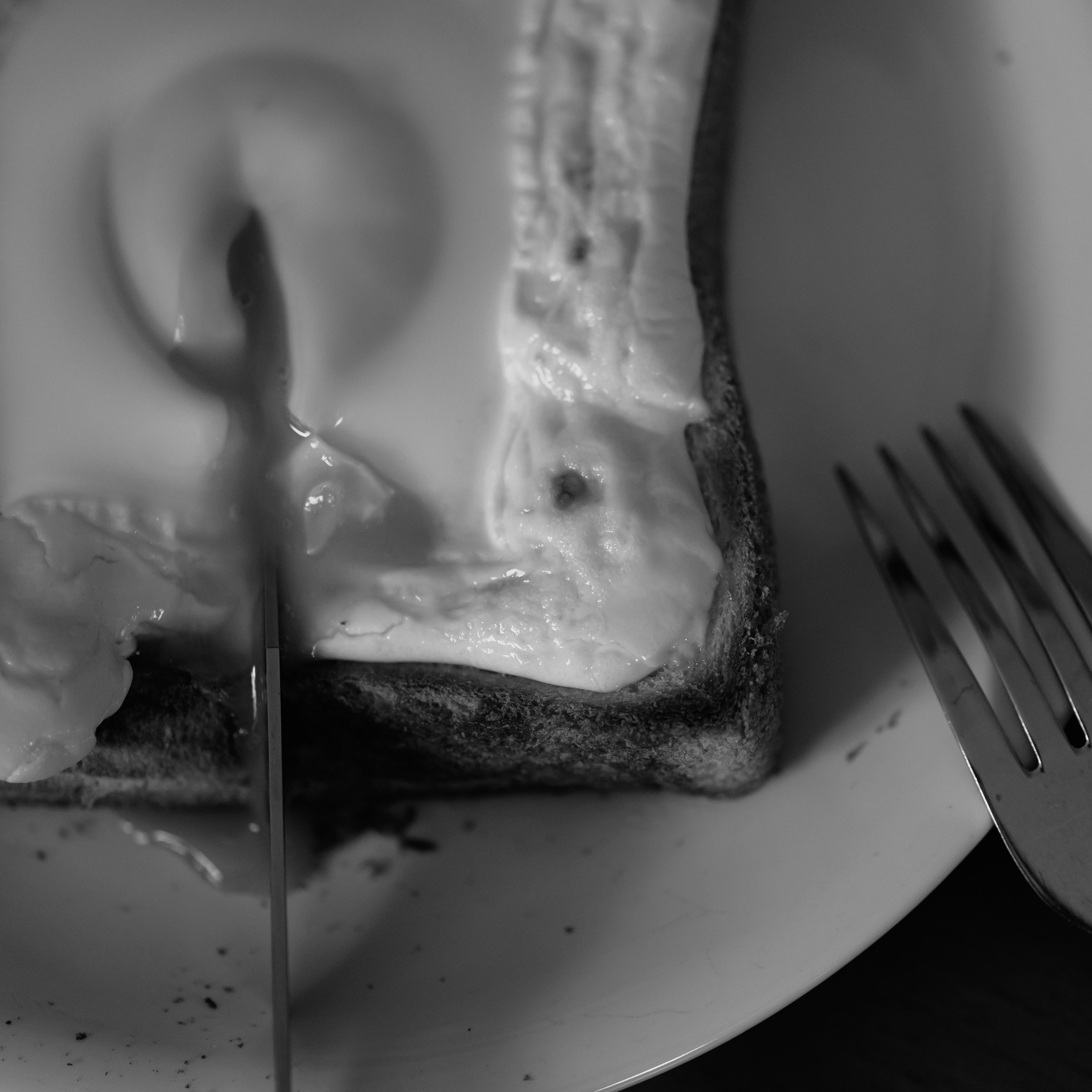 Black and white image of toast with butter knife and fork beside it