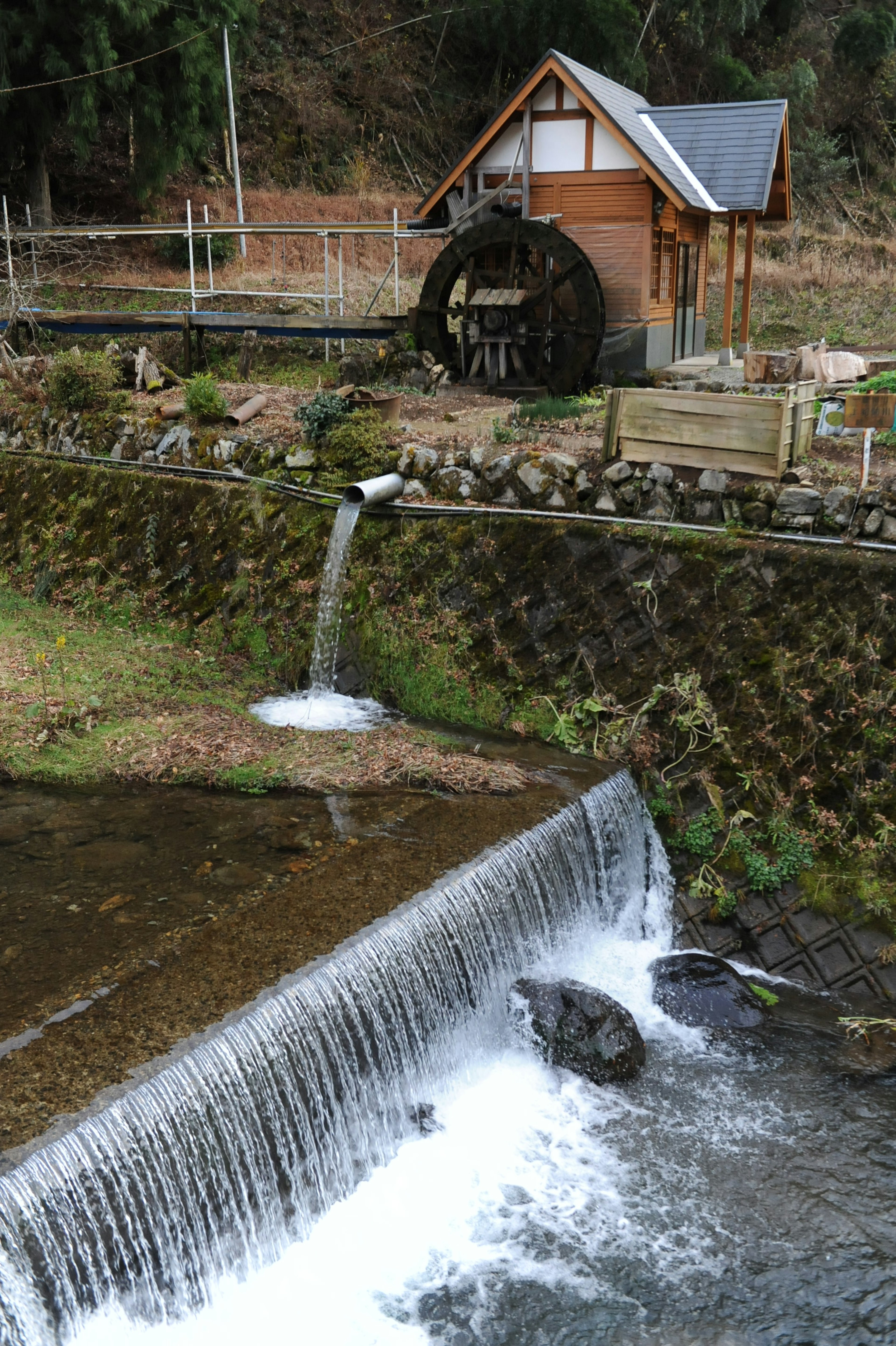 Scenic view featuring a wooden house and a waterwheel