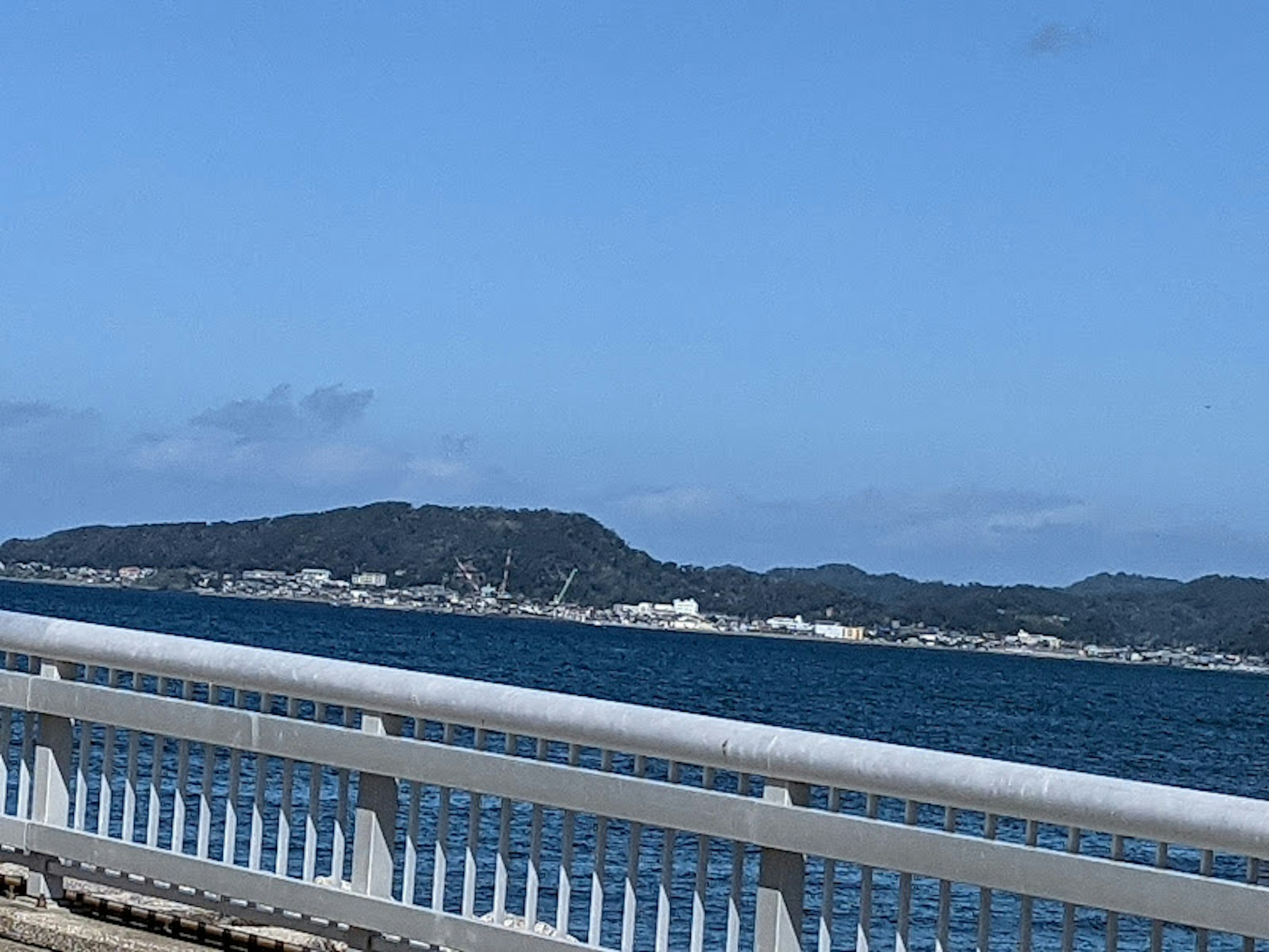 Szenenansicht von blauem Himmel und Ozean mit einer weißen Brücke