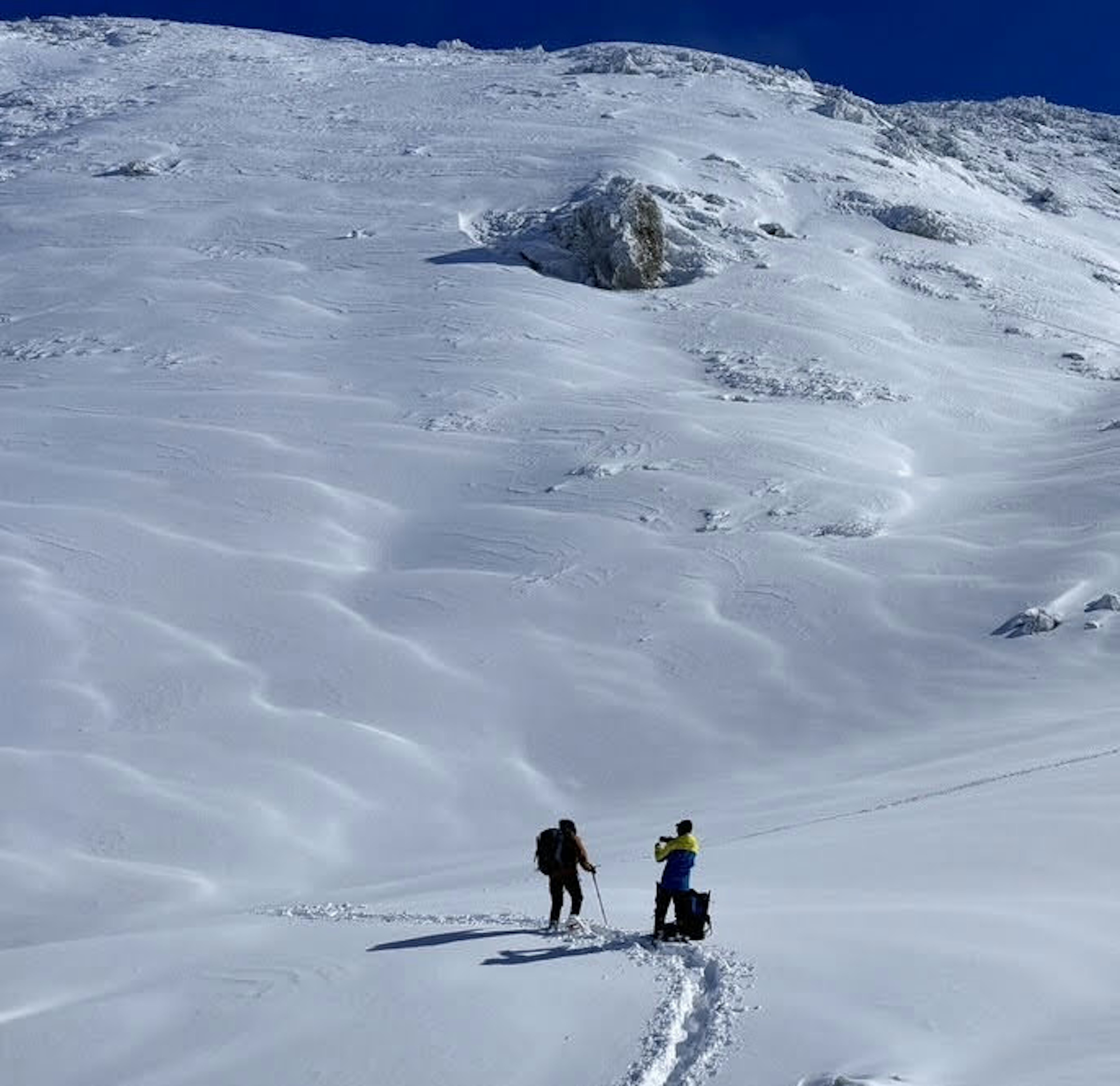 Dua pendaki mendaki gunung yang tertutup salju