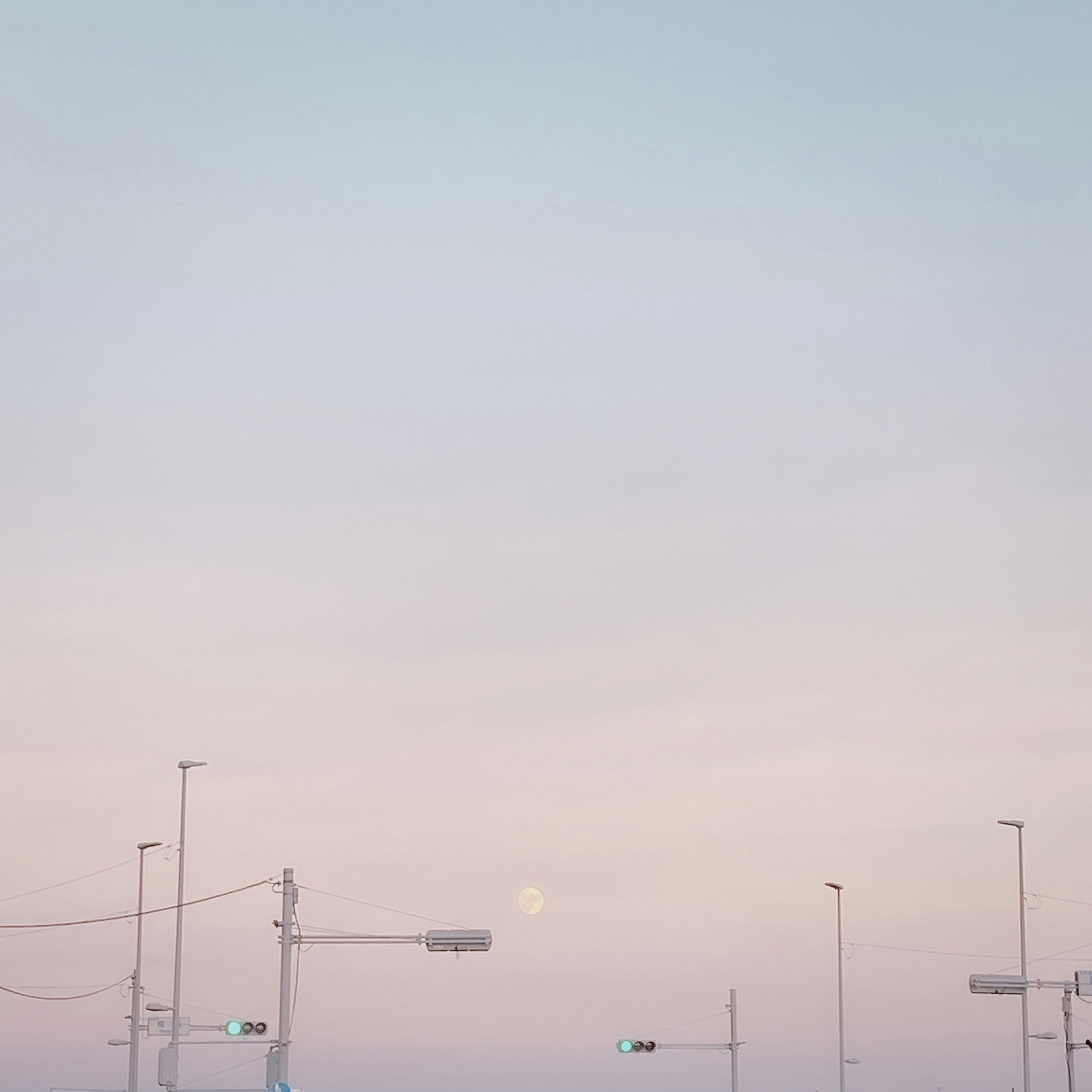 Sanfter farbiger Himmel mit sichtbarem Mond und Verkehrsampeln