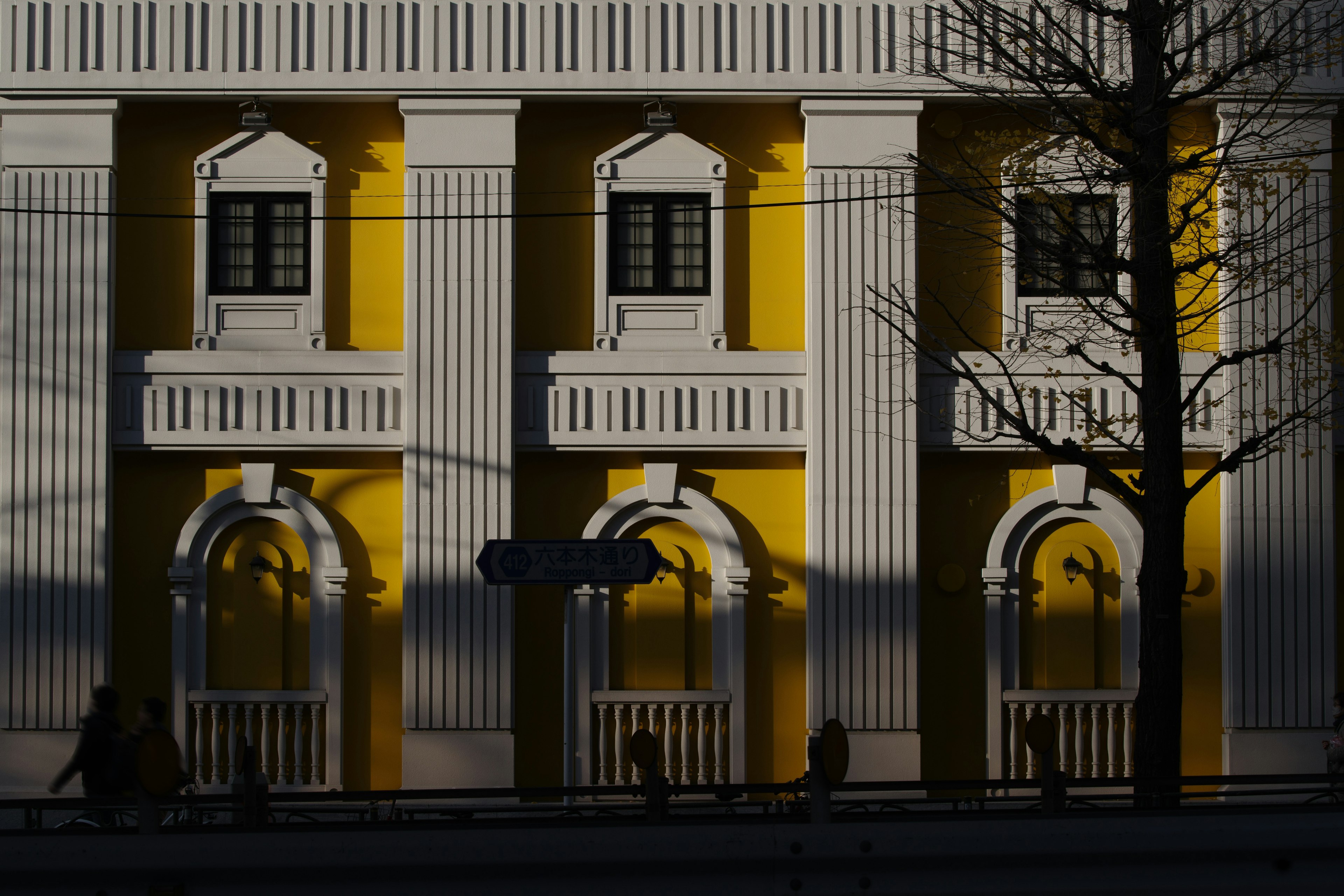 Façade d'un bâtiment jaune avec des ombres