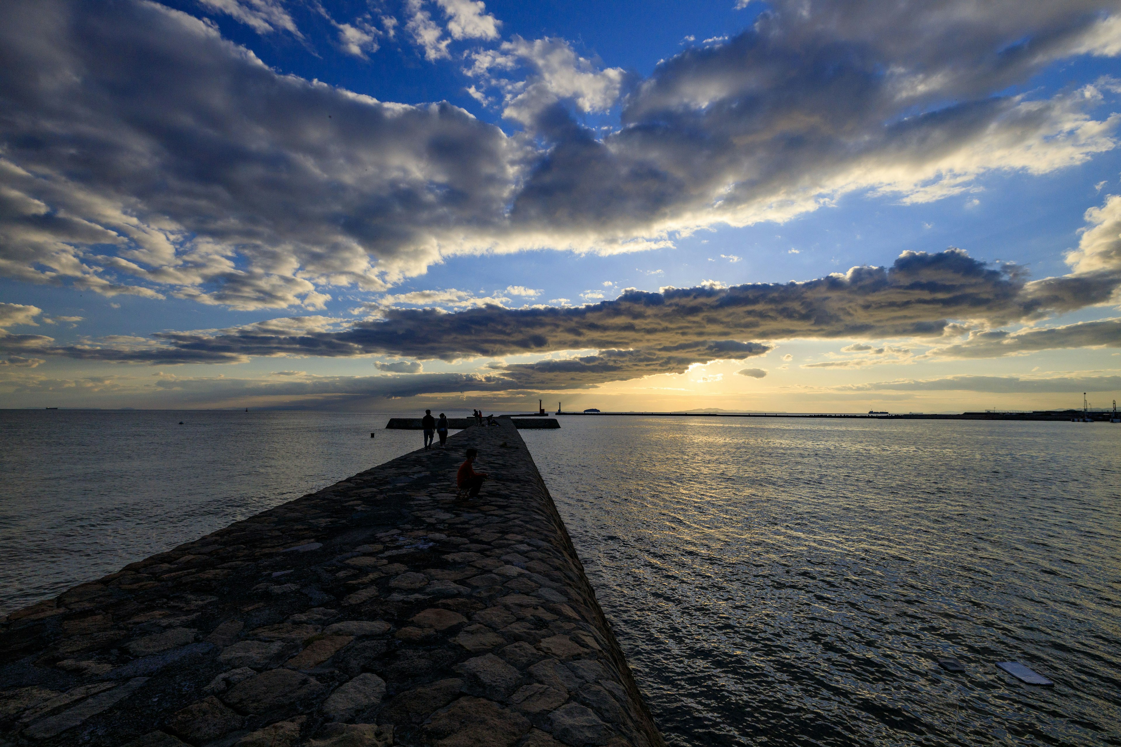 Vista panoramica di un molo che si estende nell'oceano sotto un cielo drammatico