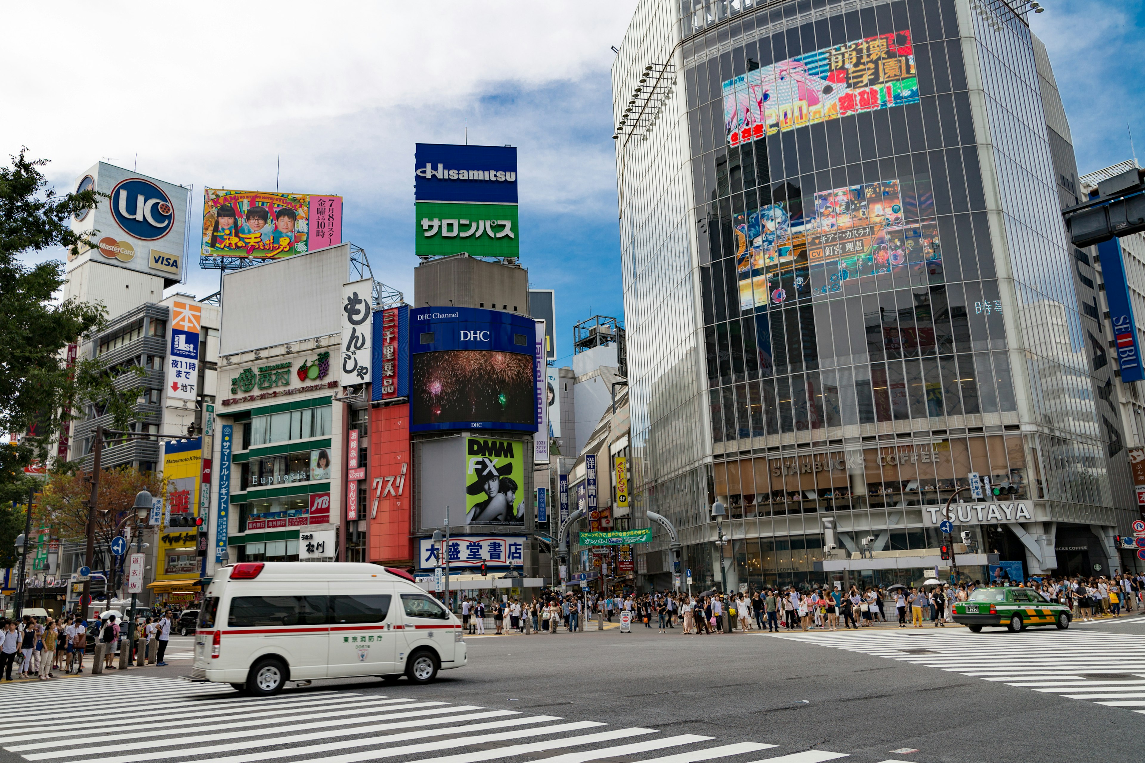 Scène animée au carrefour de Shibuya avec des publicités vibrantes