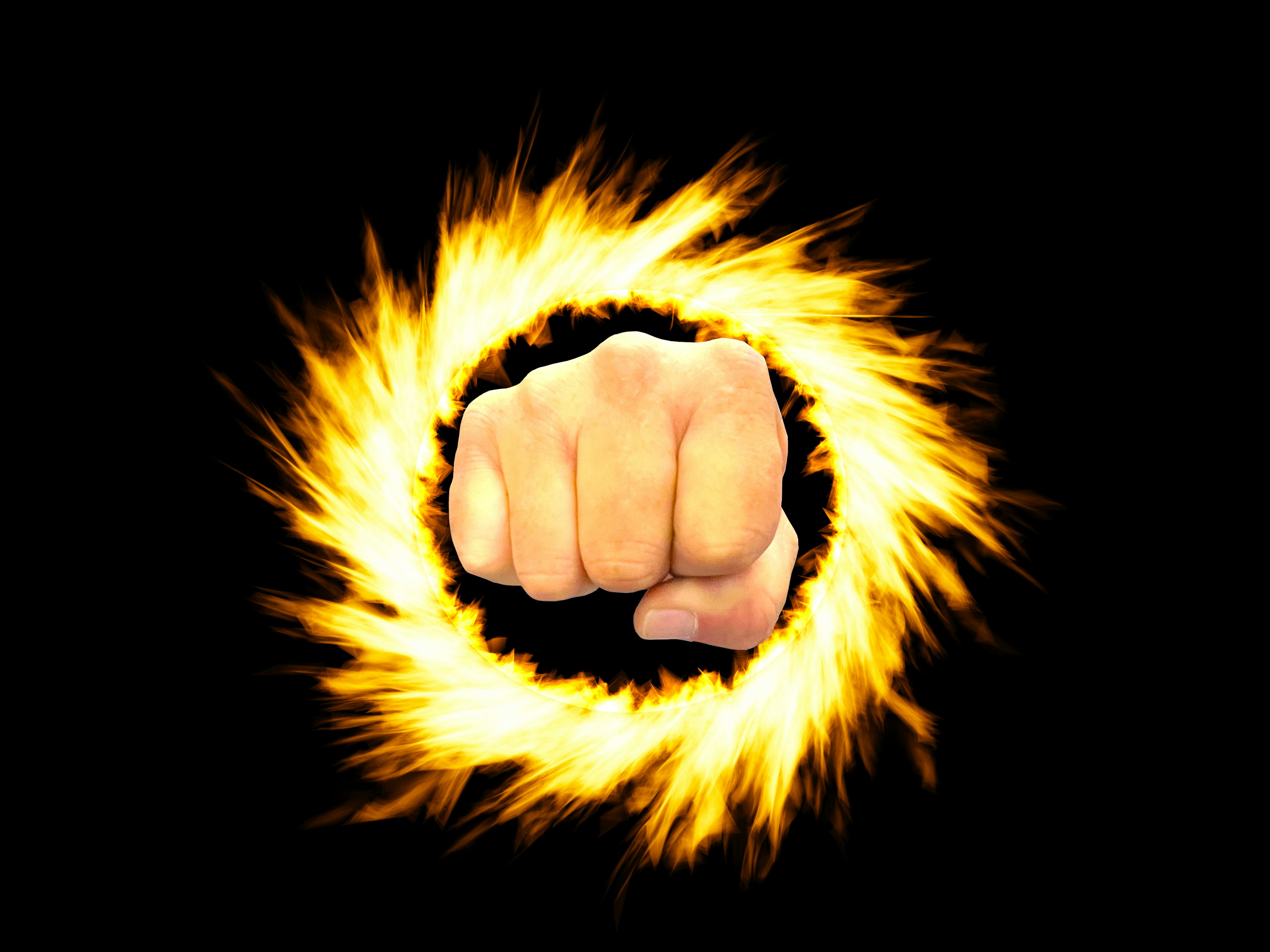 Fist breaking through a fiery ring against a black background