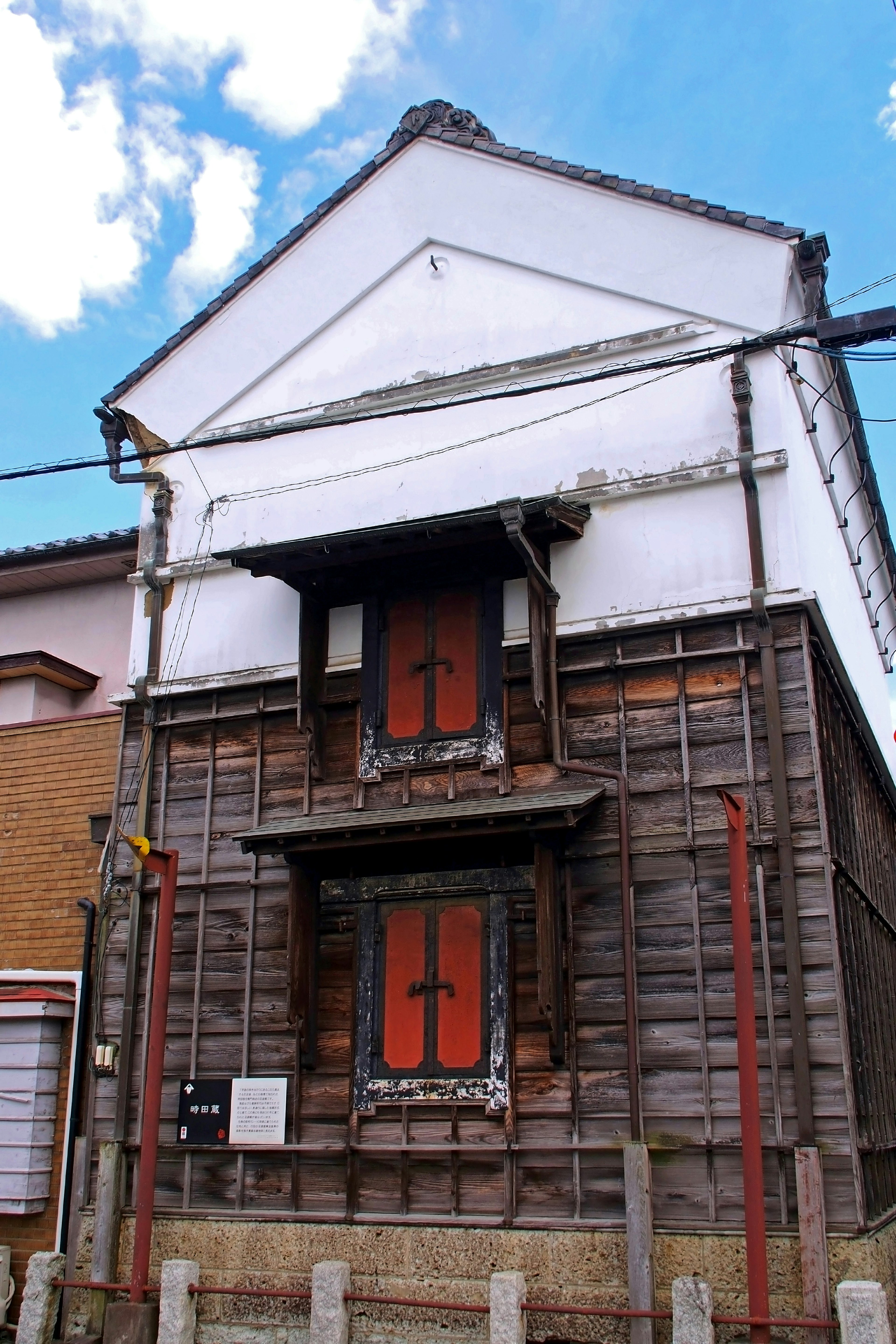 Traditional wooden building exterior featuring red doors and white walls