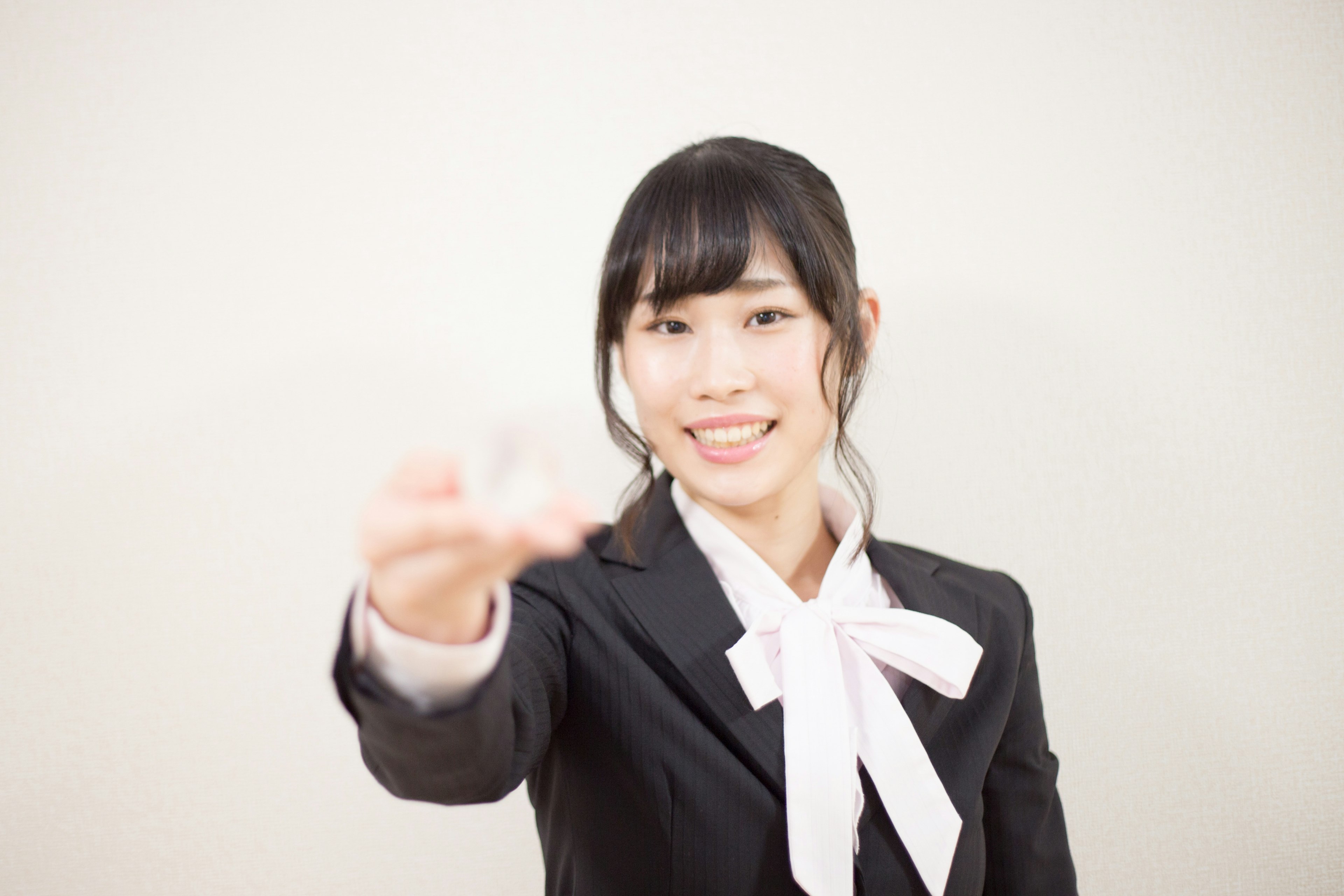 Una mujer en traje de negocios sonriendo y extendiendo la mano