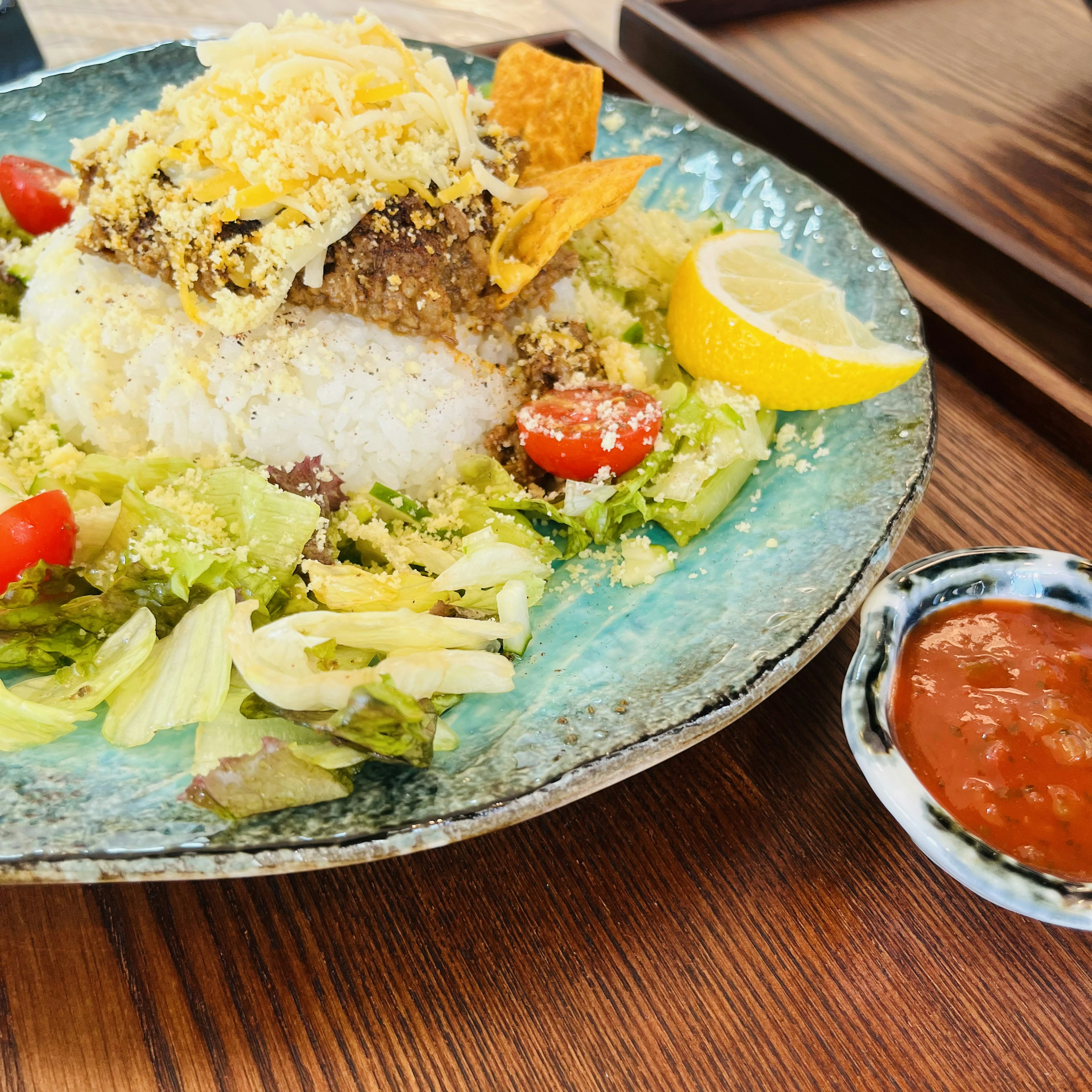 Piring nasi dan salad dengan lemon dan saus salsa di samping