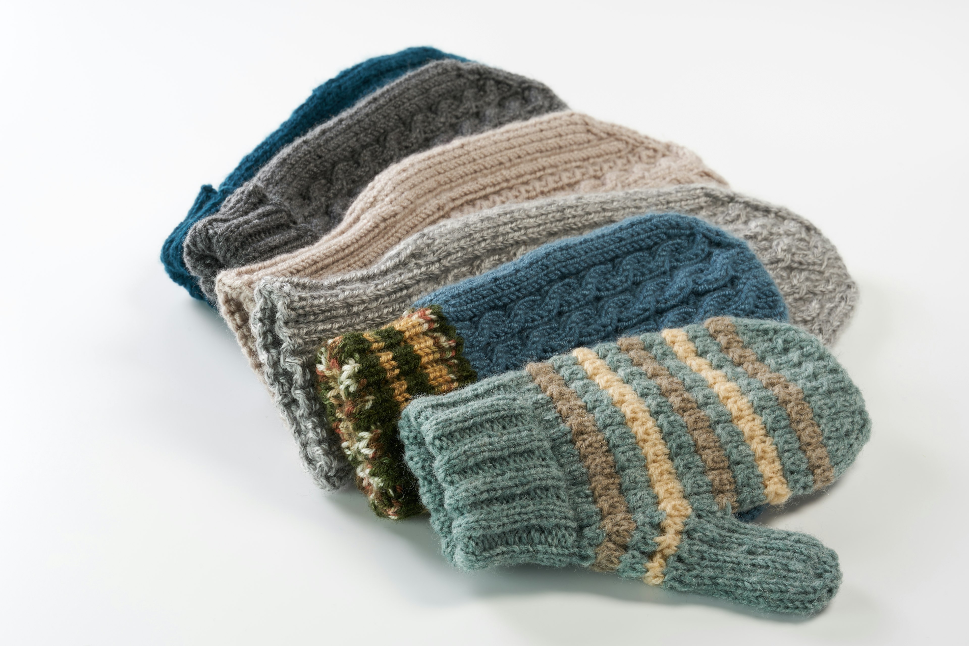 A stack of colorful knitted mittens arranged in a cozy display