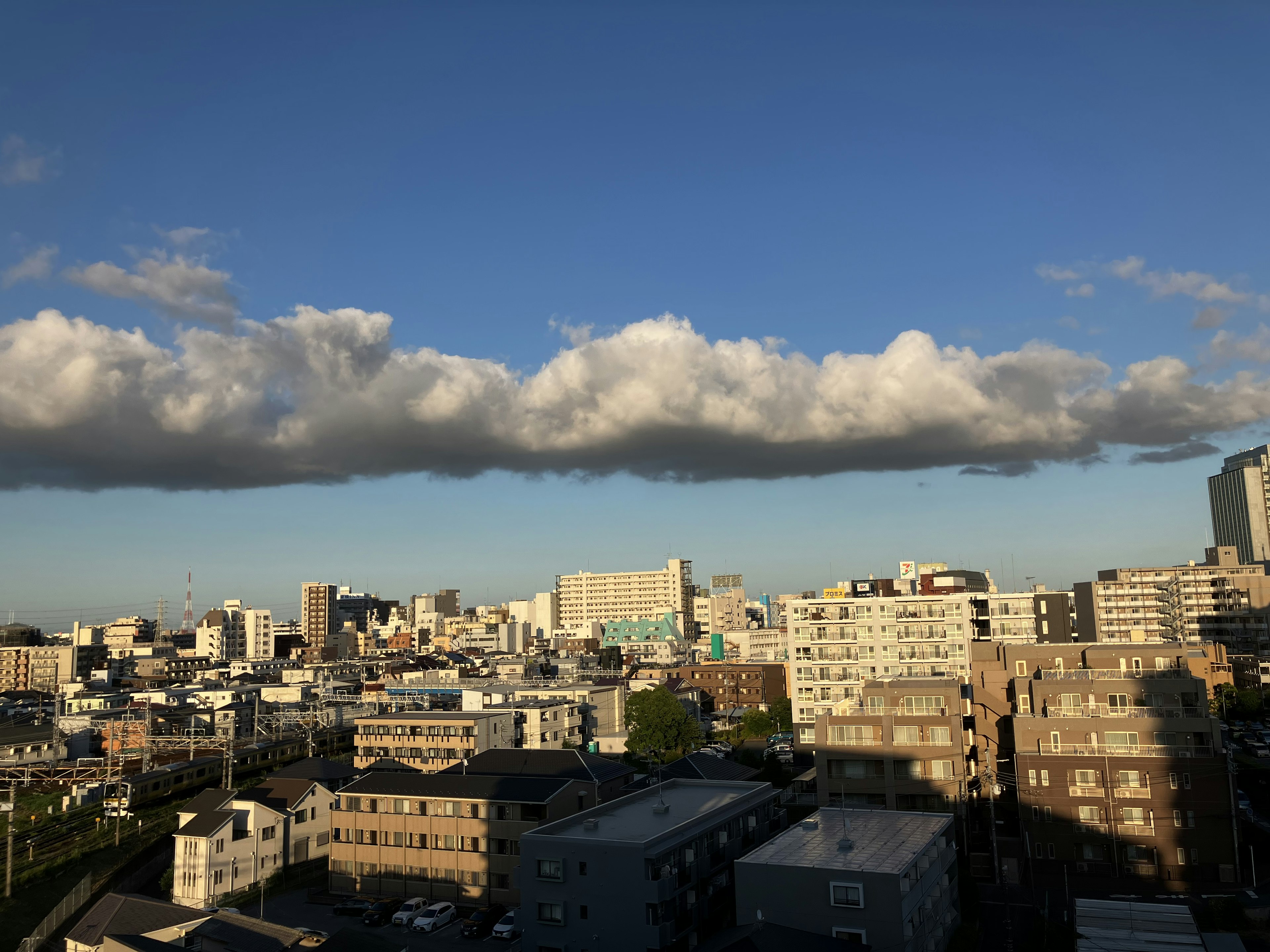 Paysage urbain avec ciel bleu et nuages comprenant des immeubles et des maisons