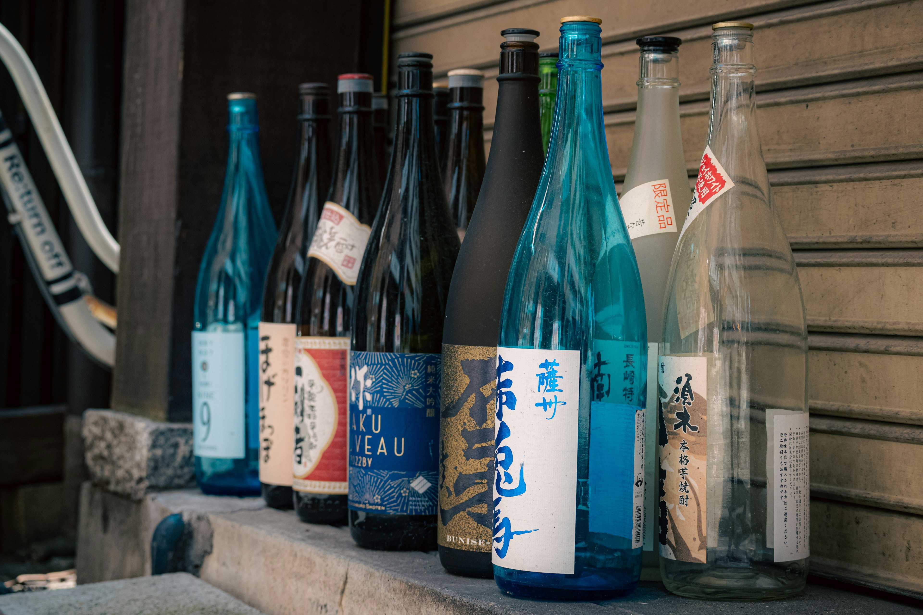 Colorful arrangement of sake bottles displayed outdoors