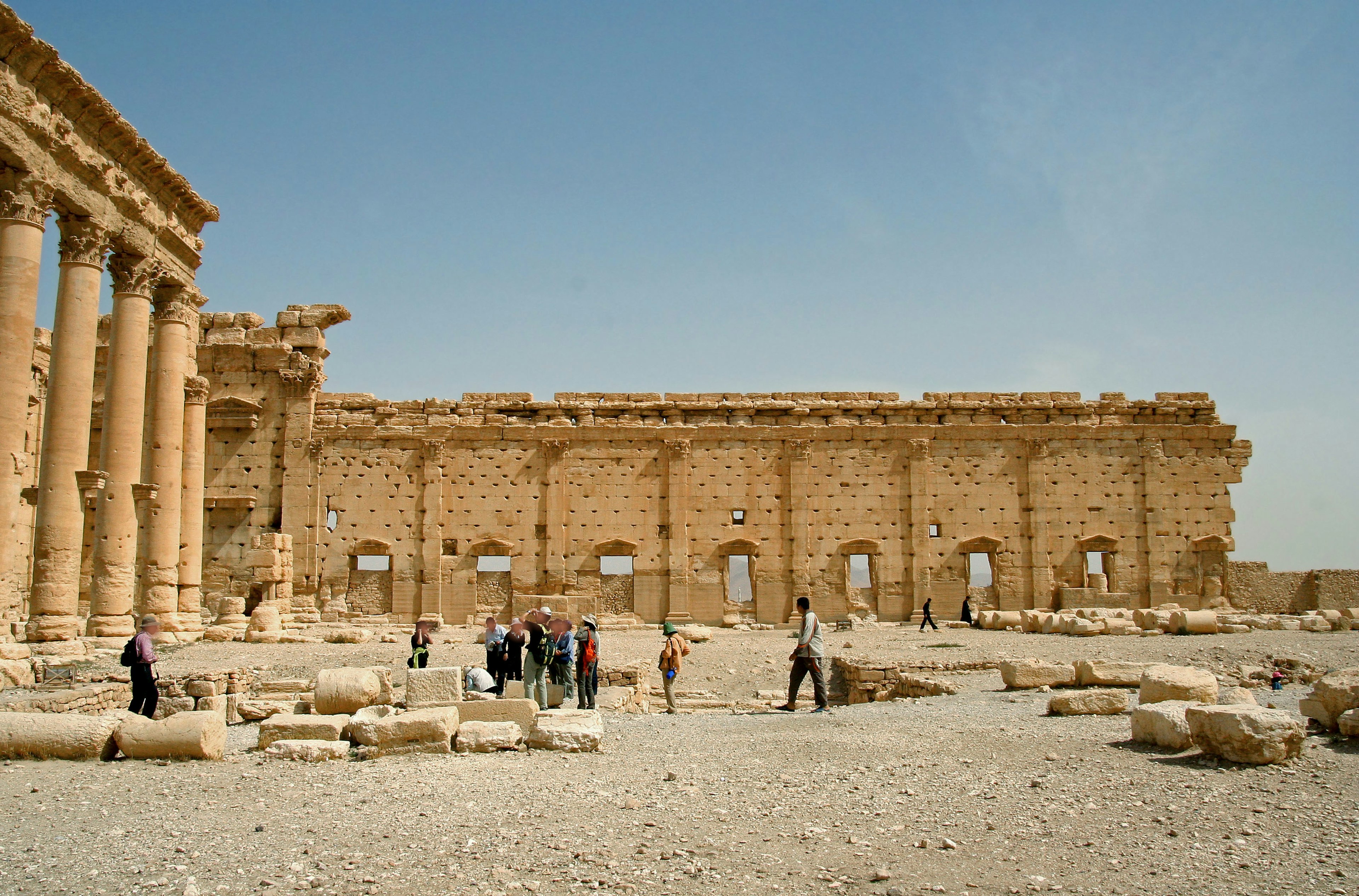 Turisti davanti a rovine antiche con colonne rotte e strutture murali