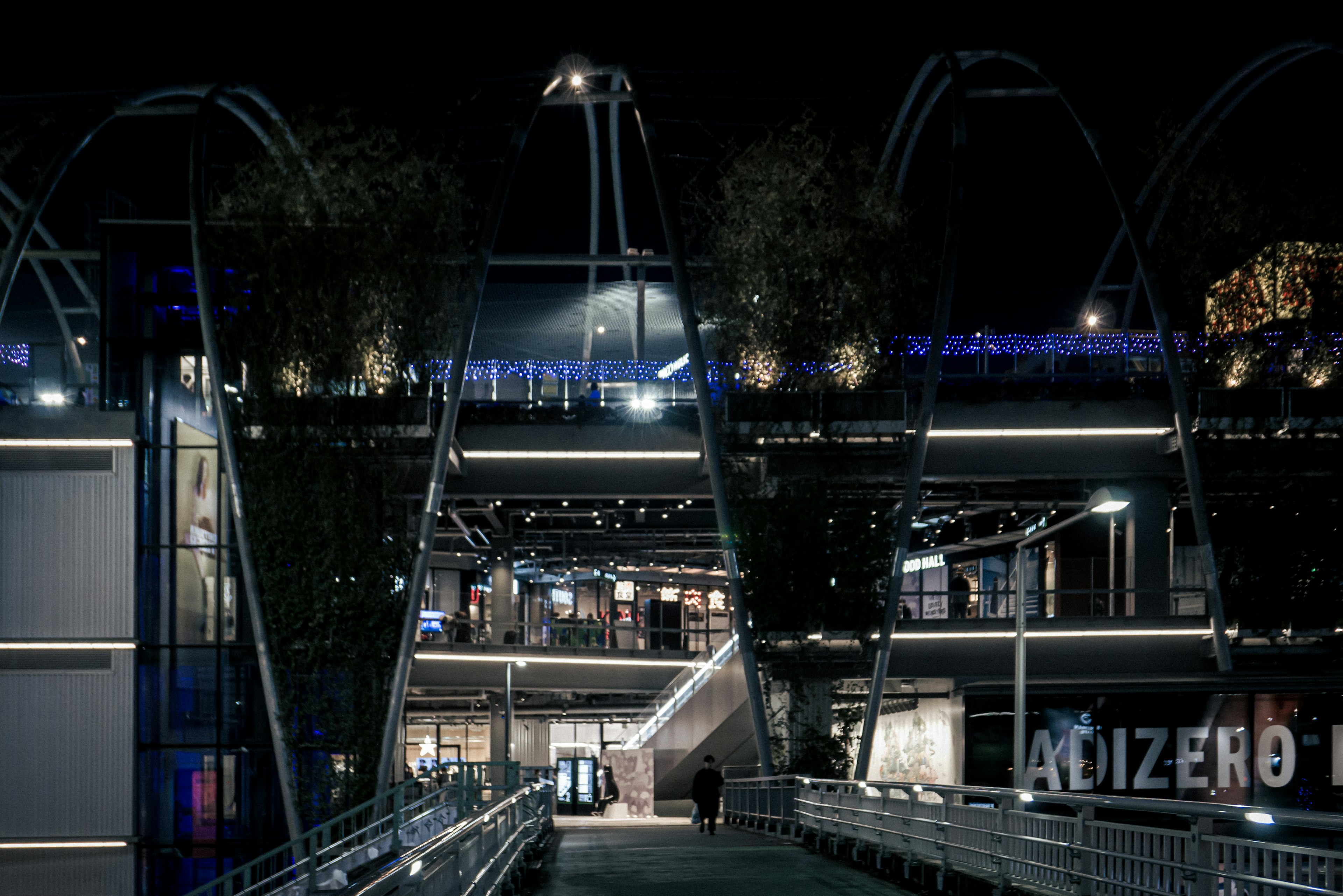 Architecture urbaine moderne illuminée la nuit avec des escaliers et des allées visibles