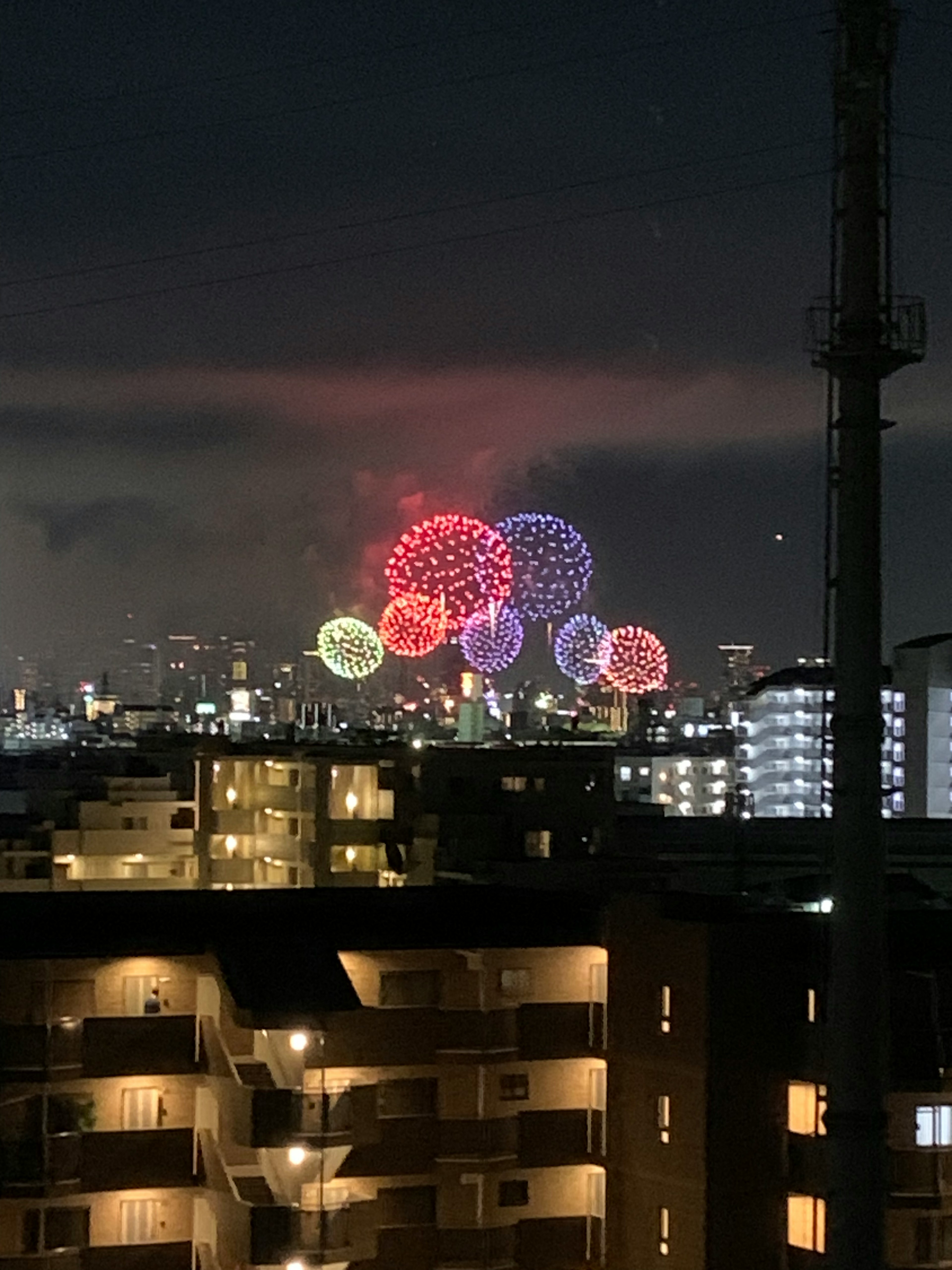 夜空に色とりどりの花火が打ち上げられた都市の景観