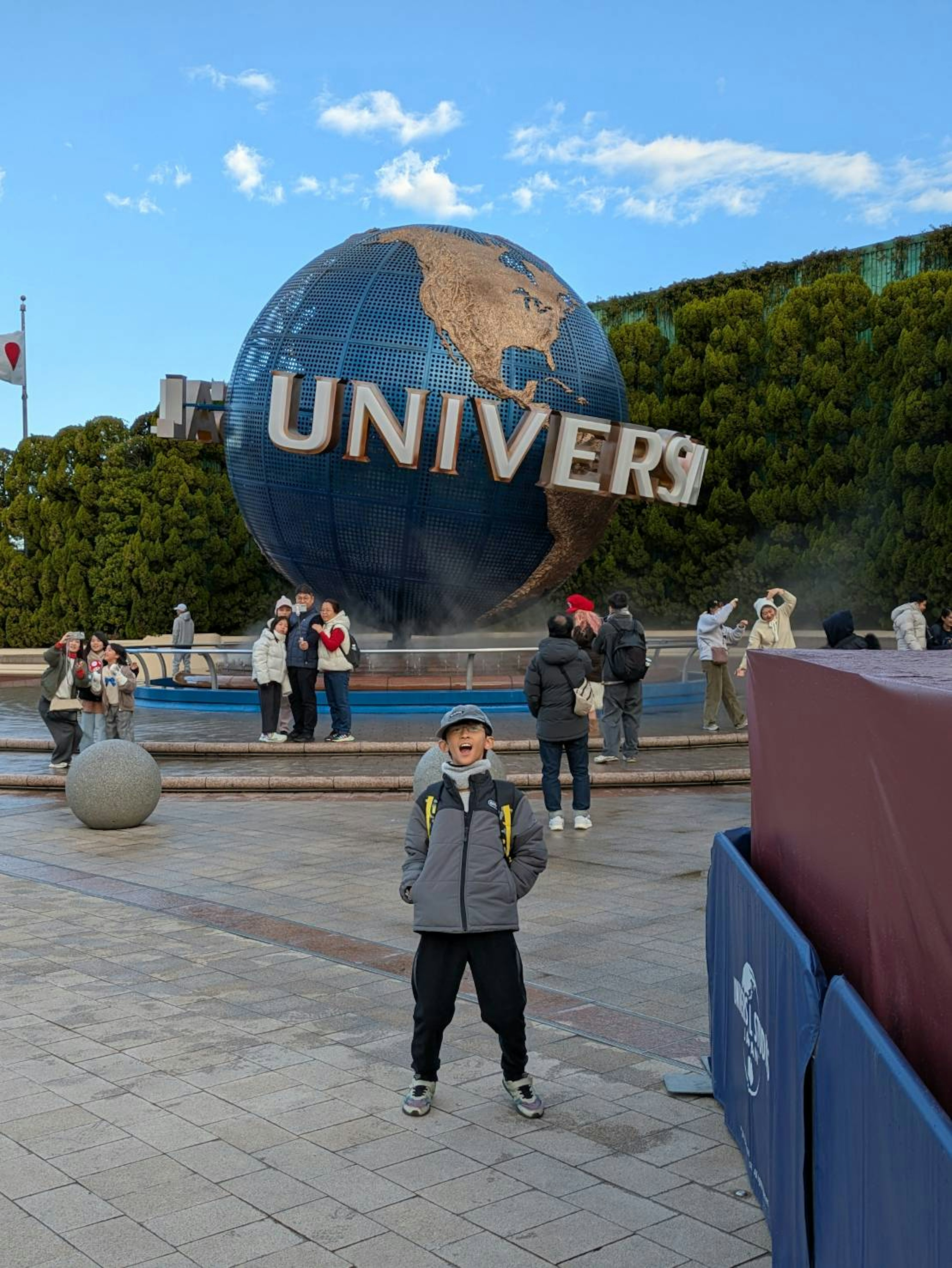 Anak berdiri di depan globe Universal Studios