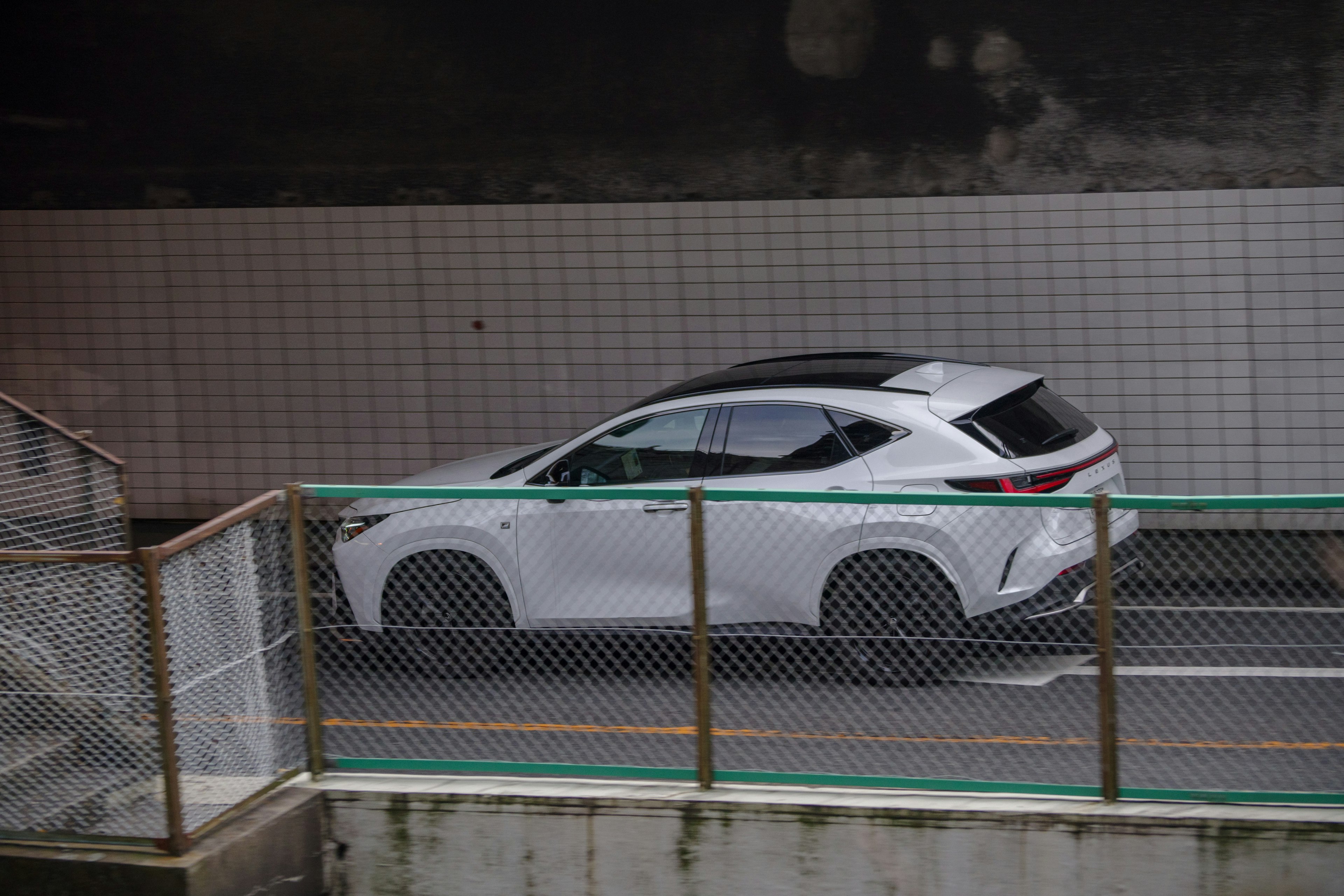 A white SUV seen through a fence