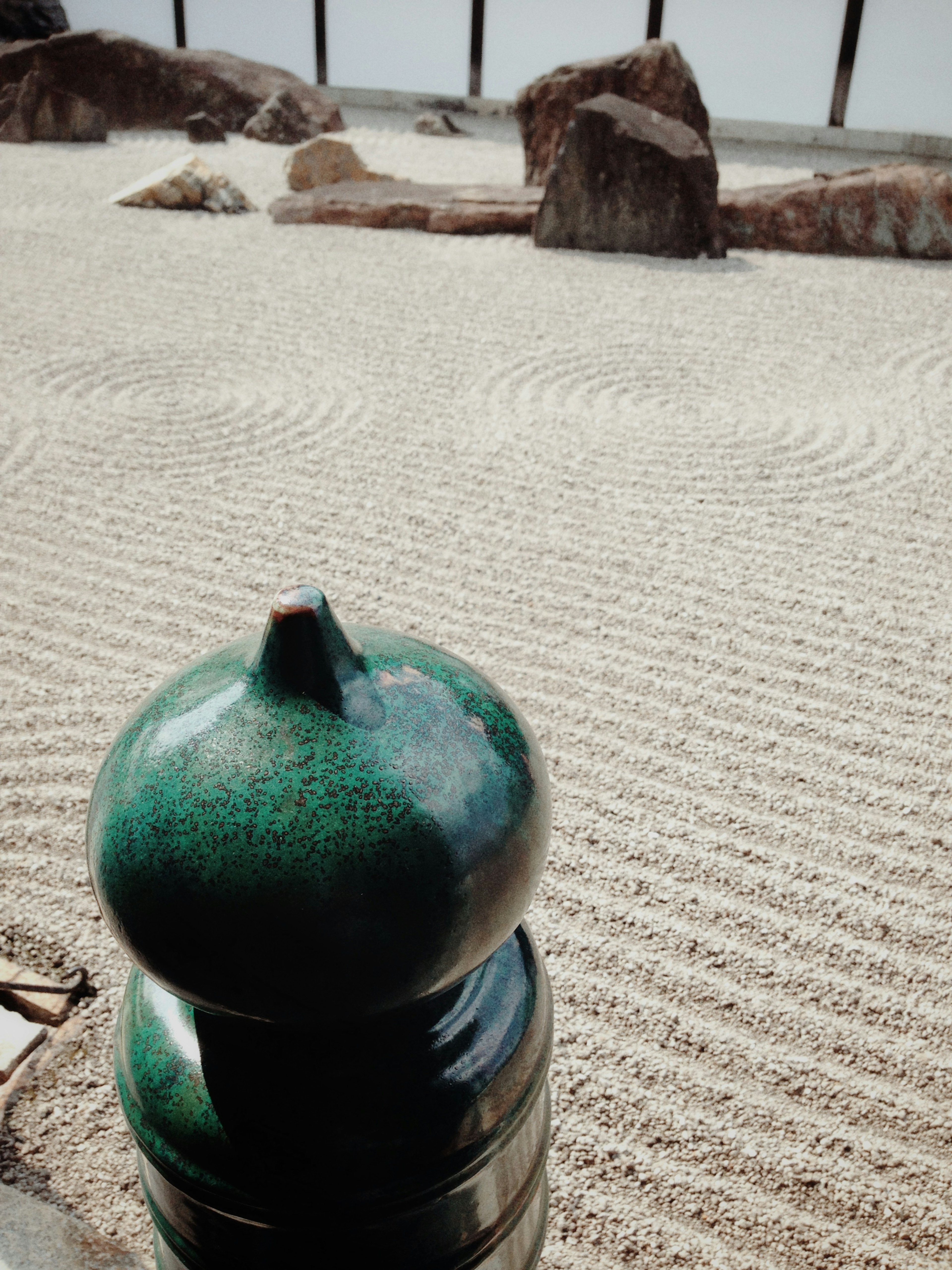 Green stone-like object with a gravel garden landscape