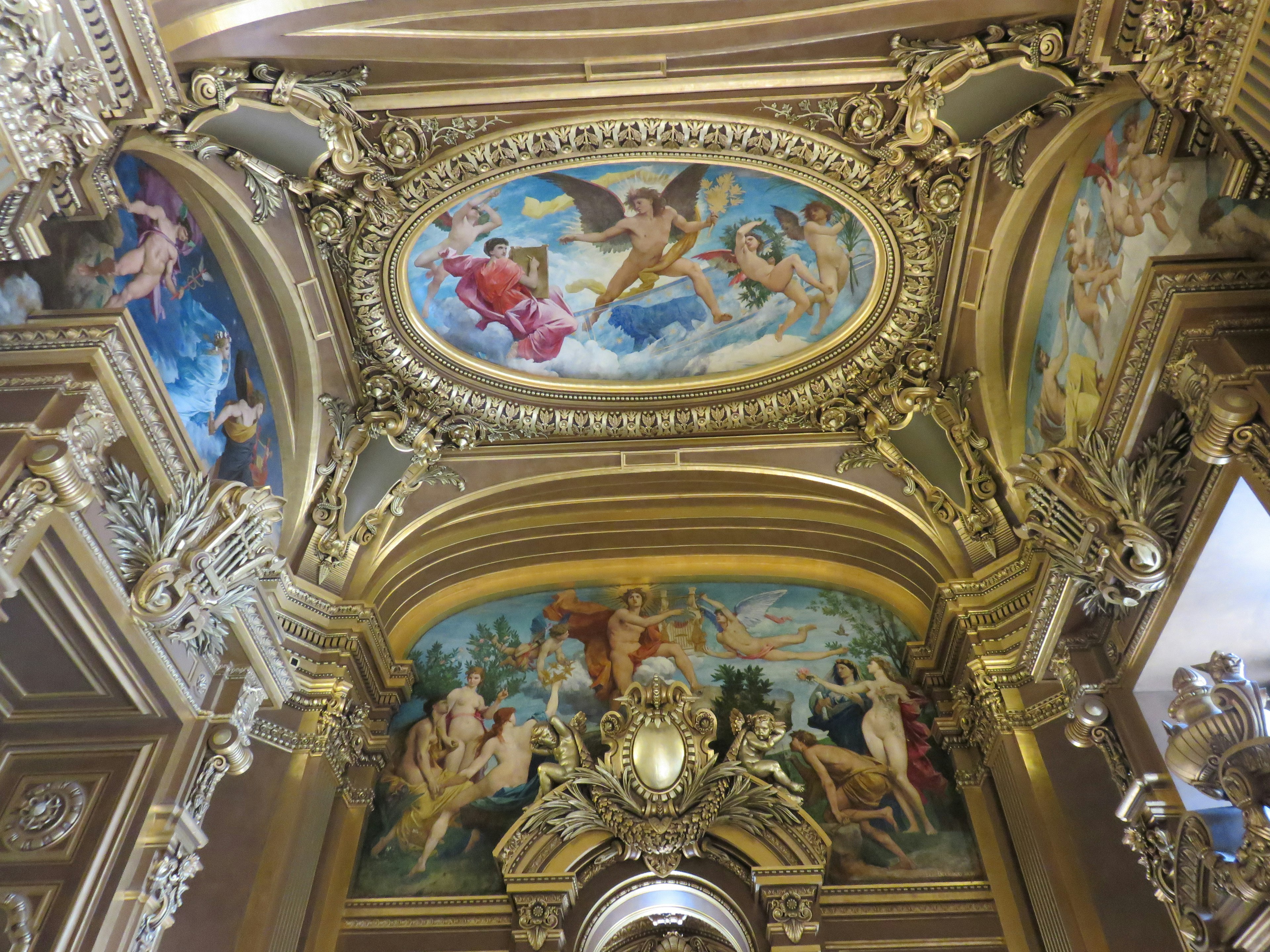 Ornate golden decorations and beautiful ceiling paintings inside a building