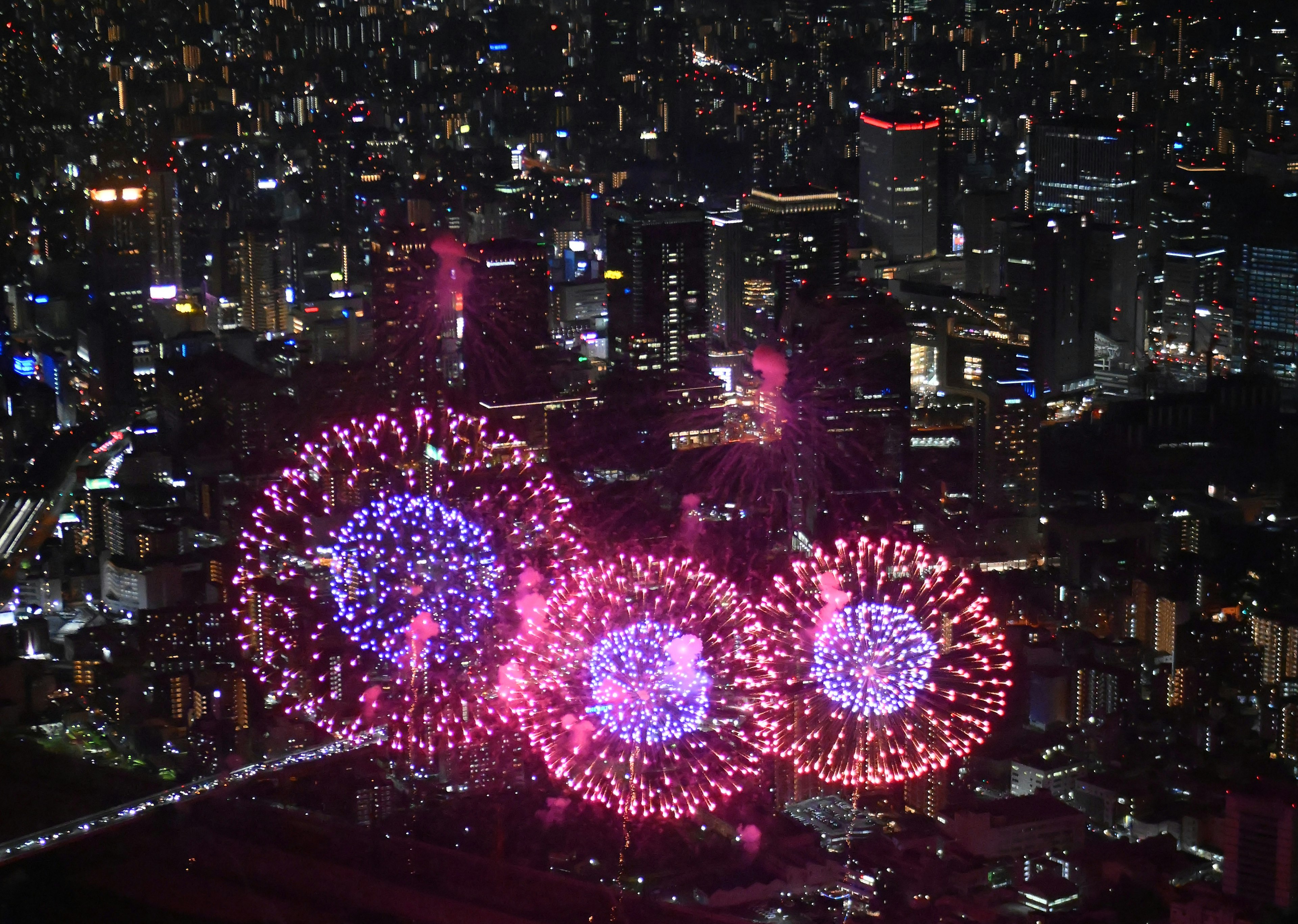 夜空に輝く花火と都市の夜景