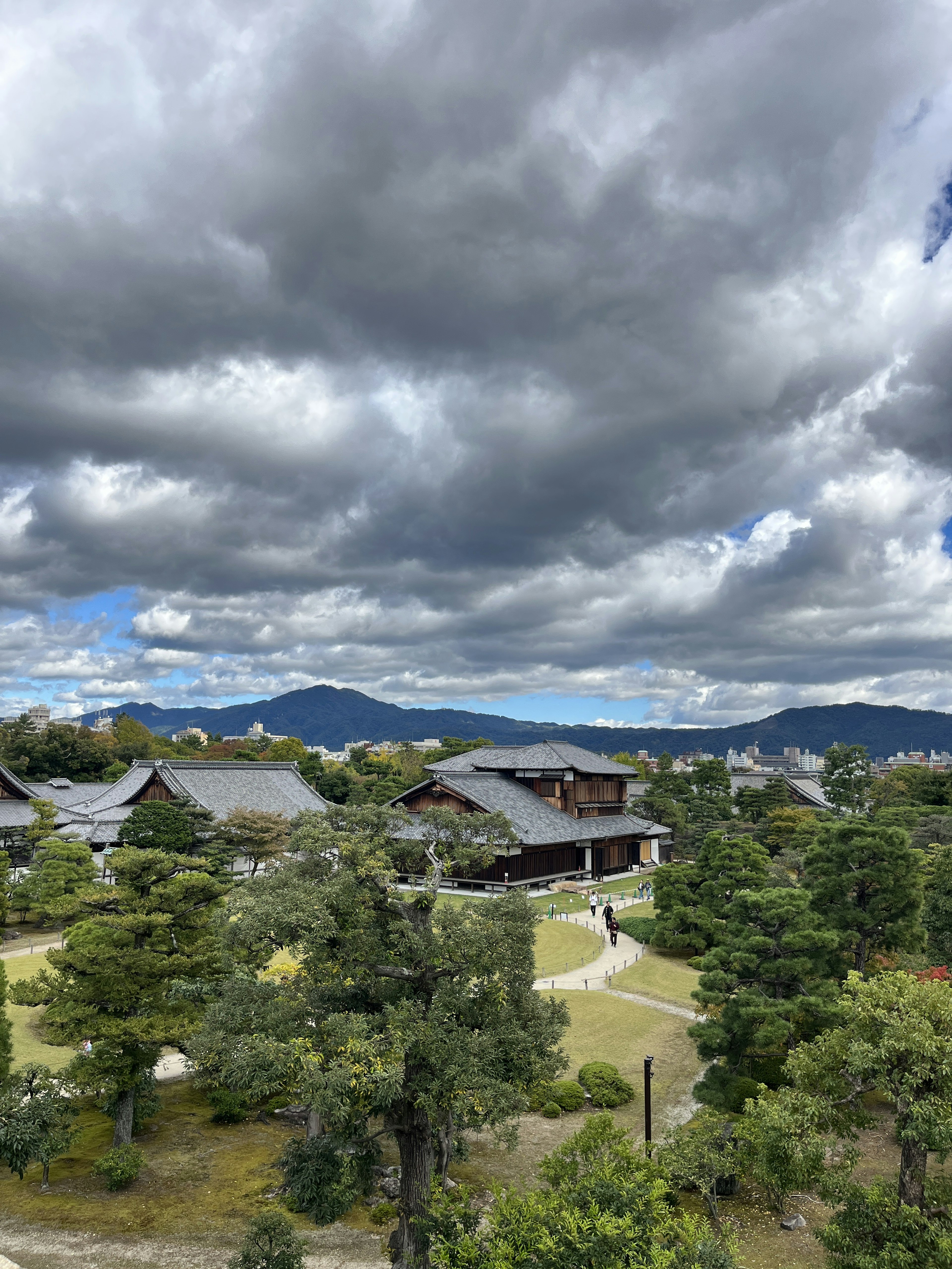 Paisaje japonés bajo un cielo nublado con casas tradicionales y vegetación exuberante