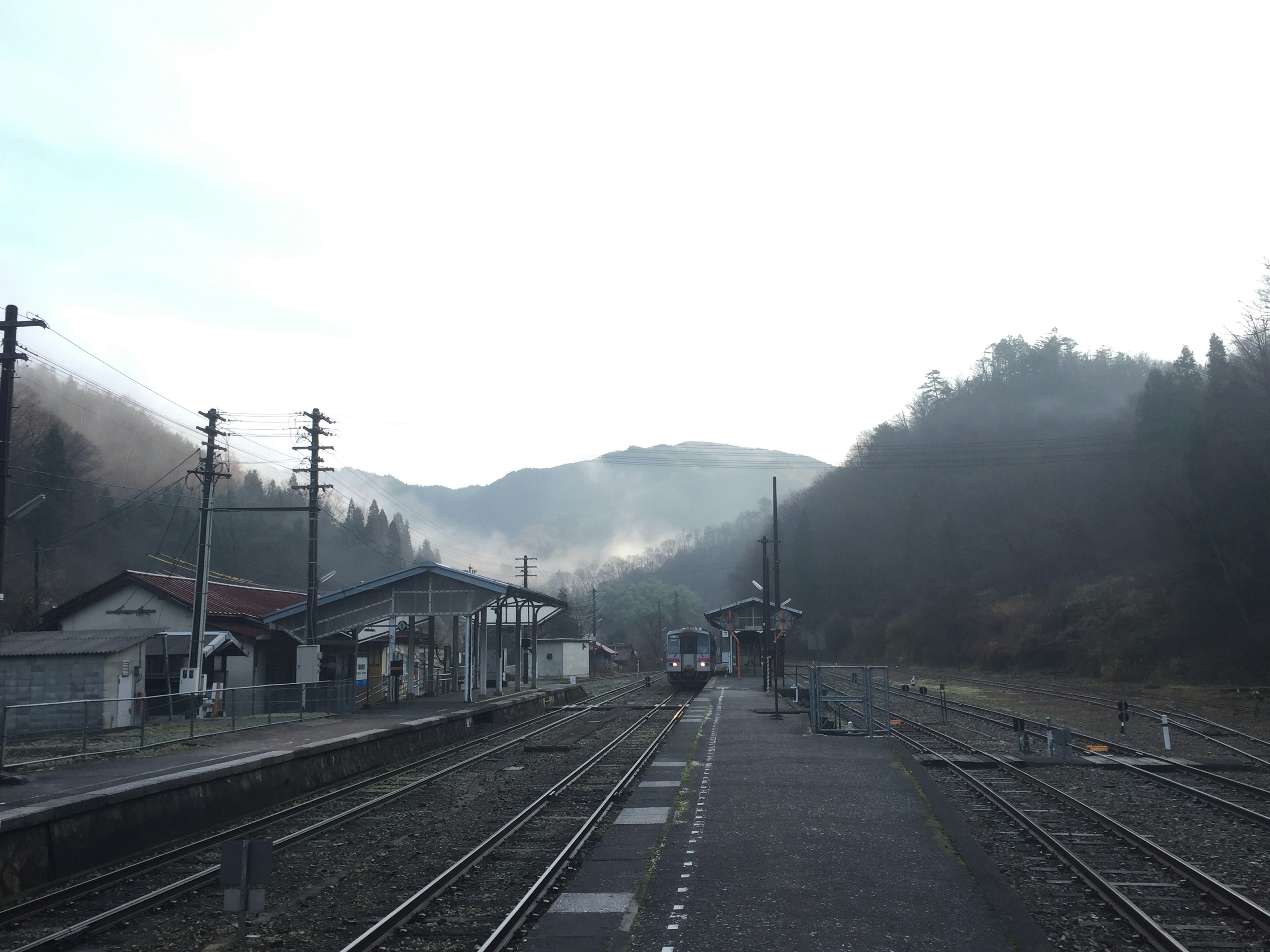 乡村火车站的风景，背景有山和雾