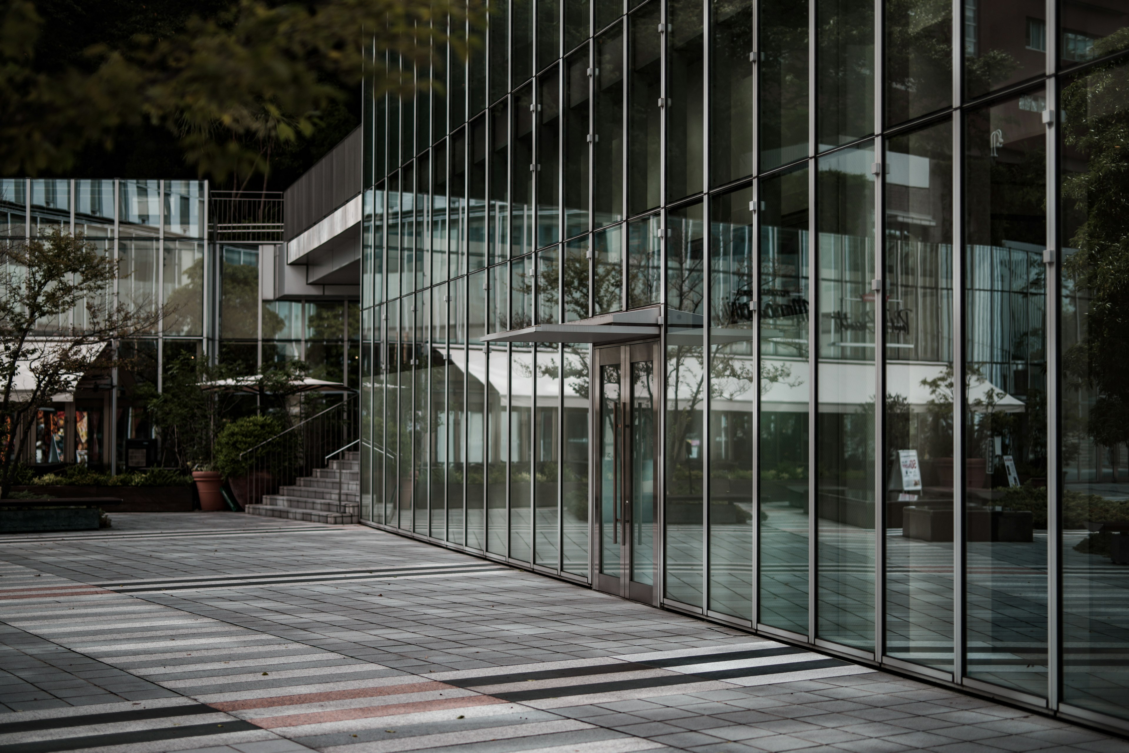 Bâtiment en verre moderne avec un chemin pavé en pierre