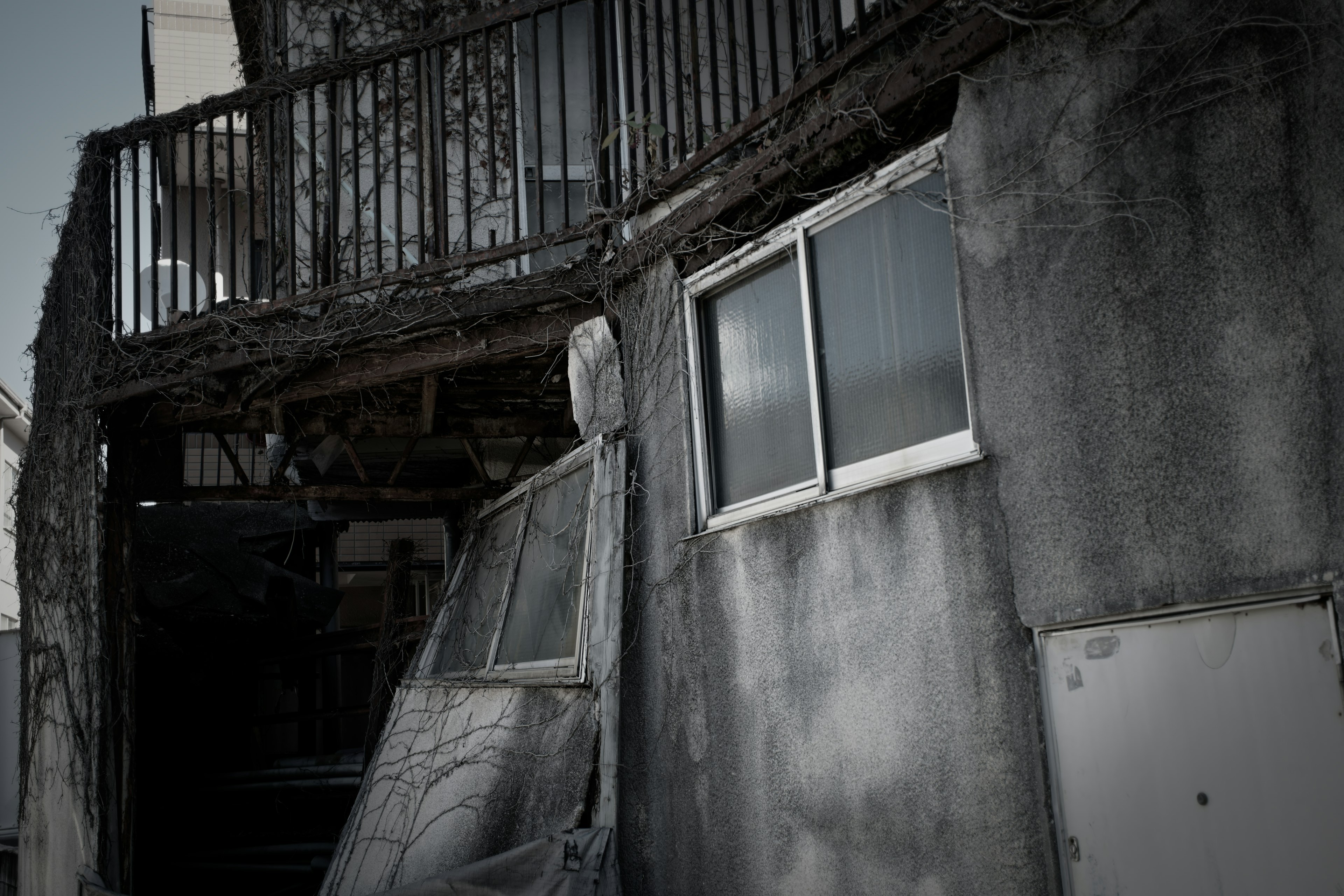 Image of an old building exterior featuring a window and a slanted wall