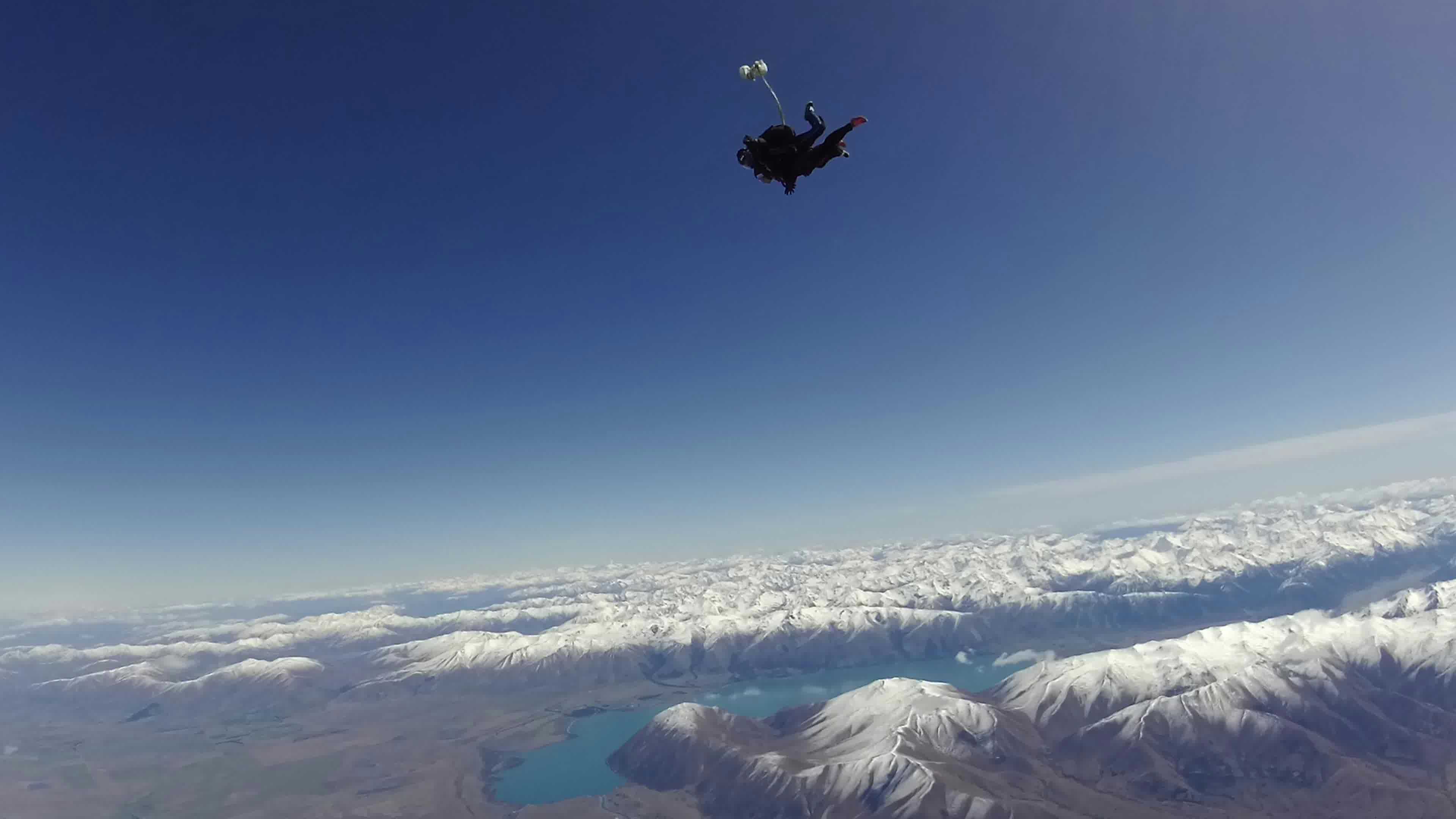 空を飛ぶパラシュートのジャンパーと美しい山々の風景