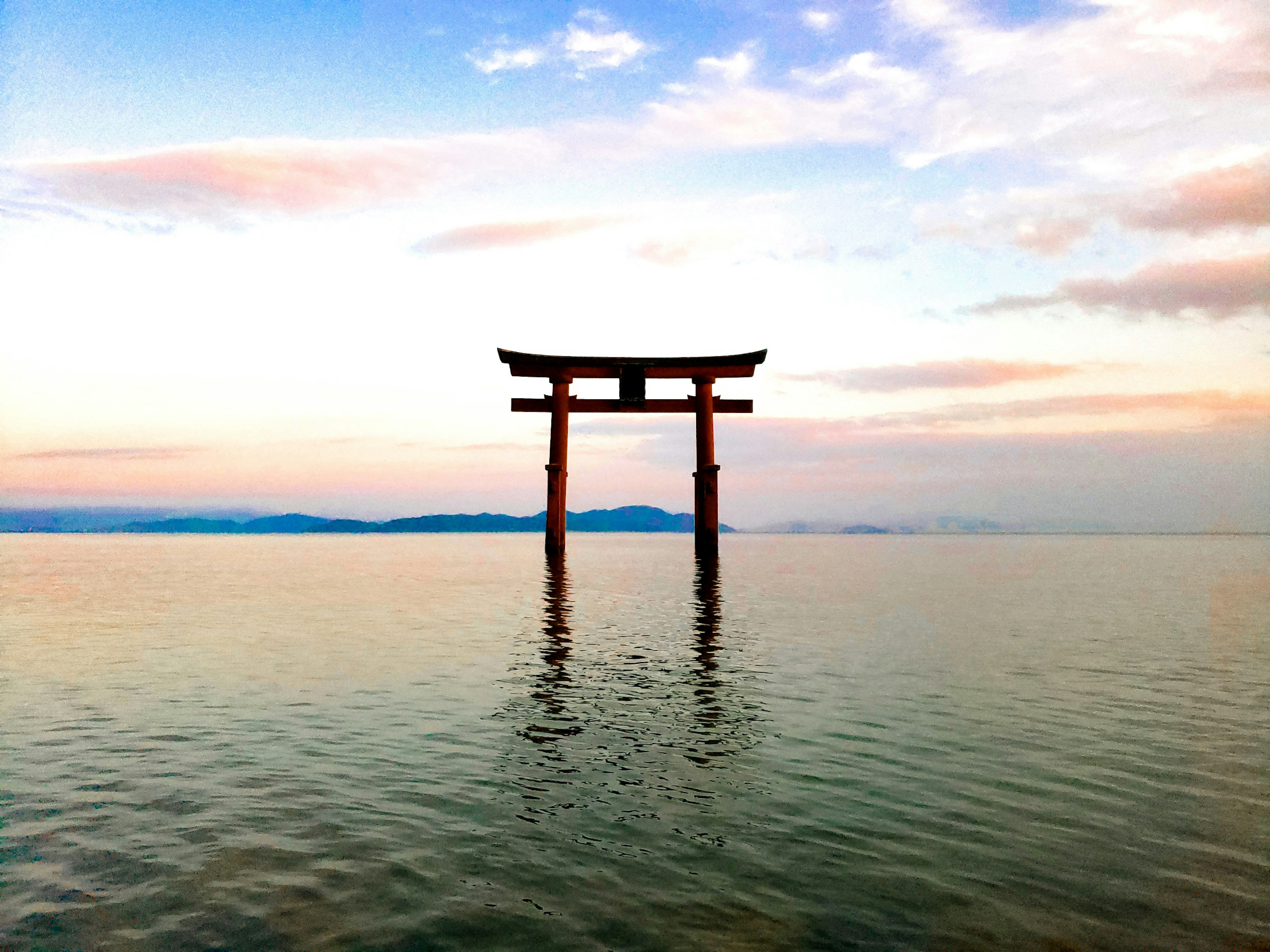 Gerbang torii berdiri di air dengan langit yang indah