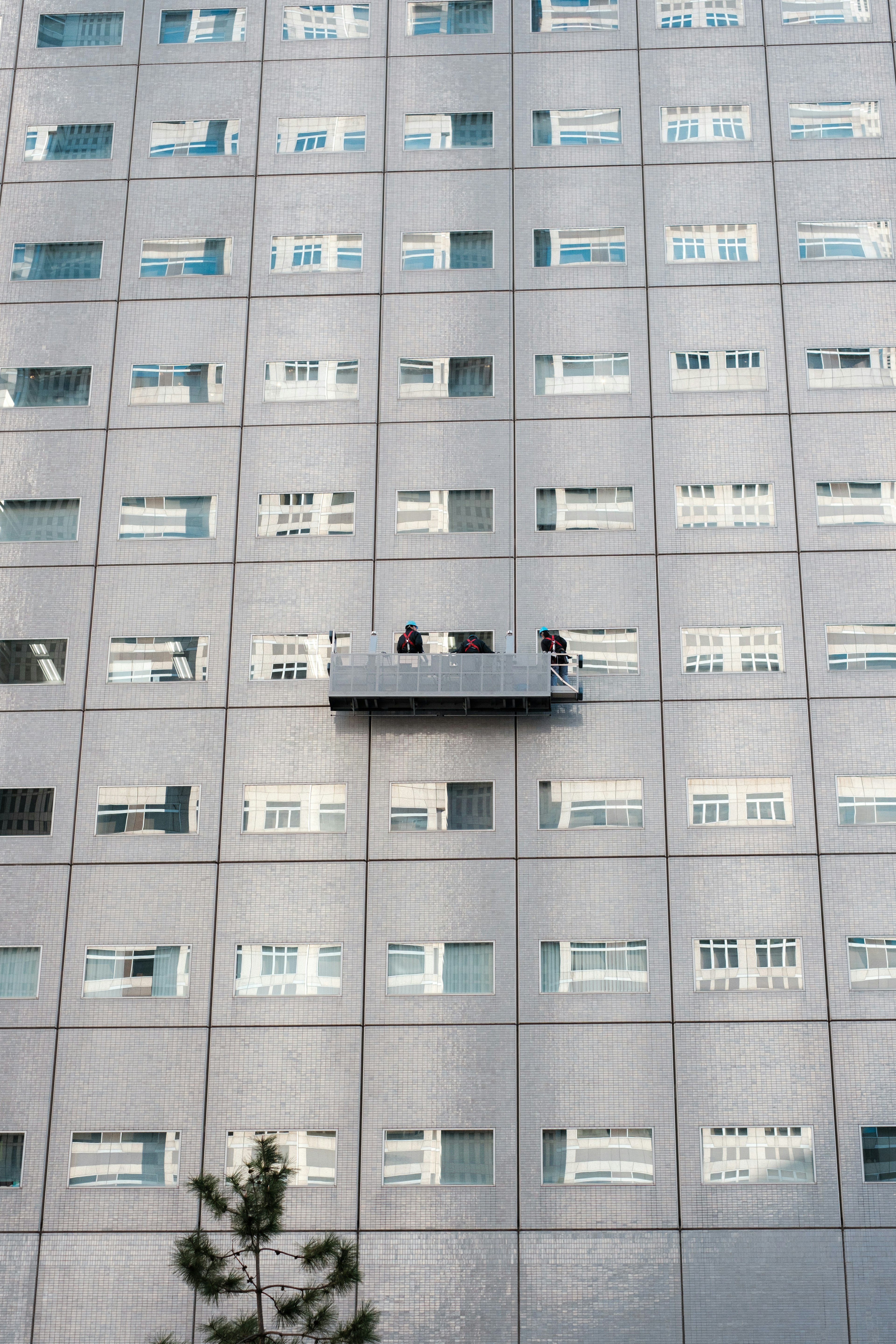 Two people on a balcony attached to the exterior of a high-rise building