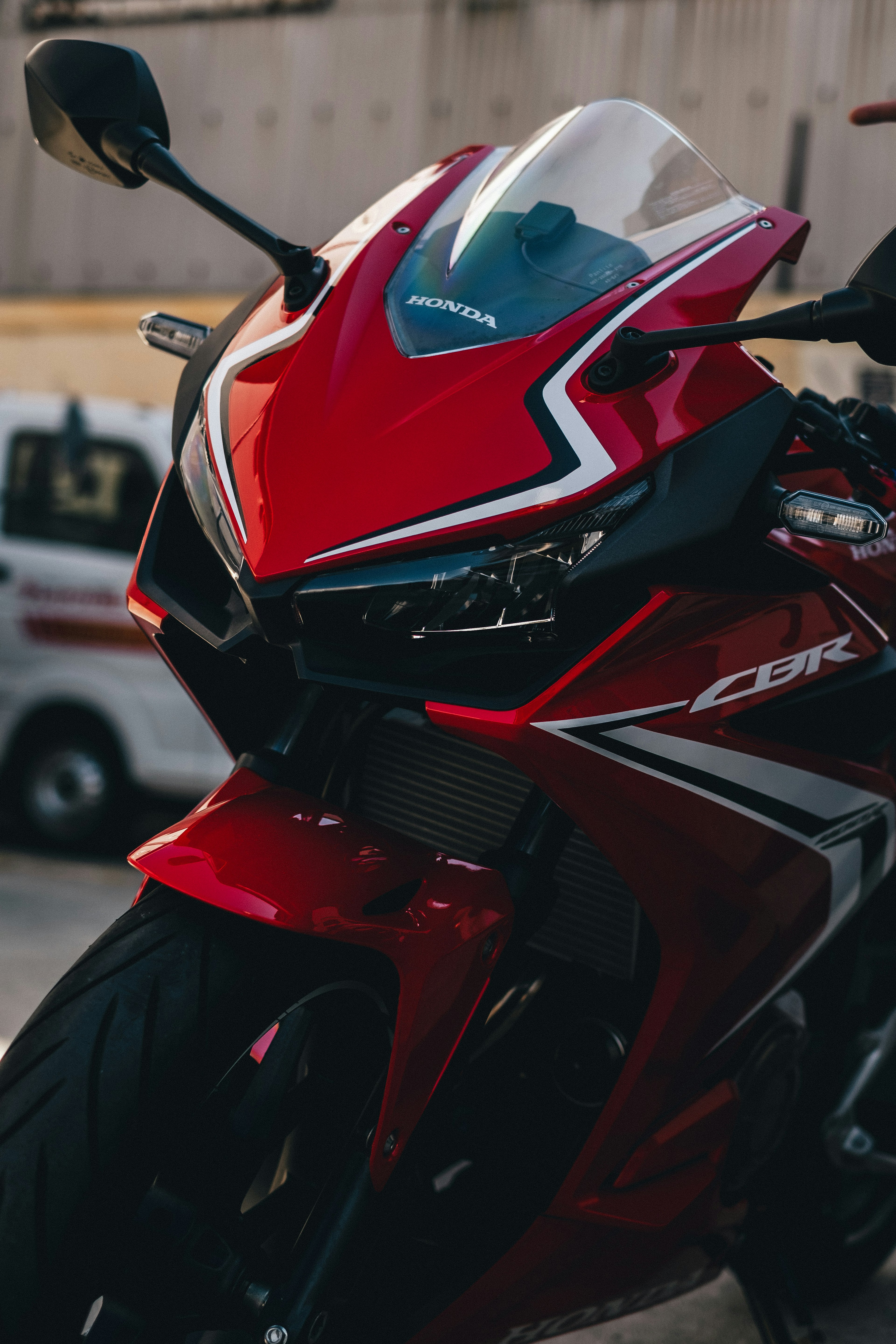 Primer plano de una moto deportiva roja que destaca el faro y el diseño aerodinámico