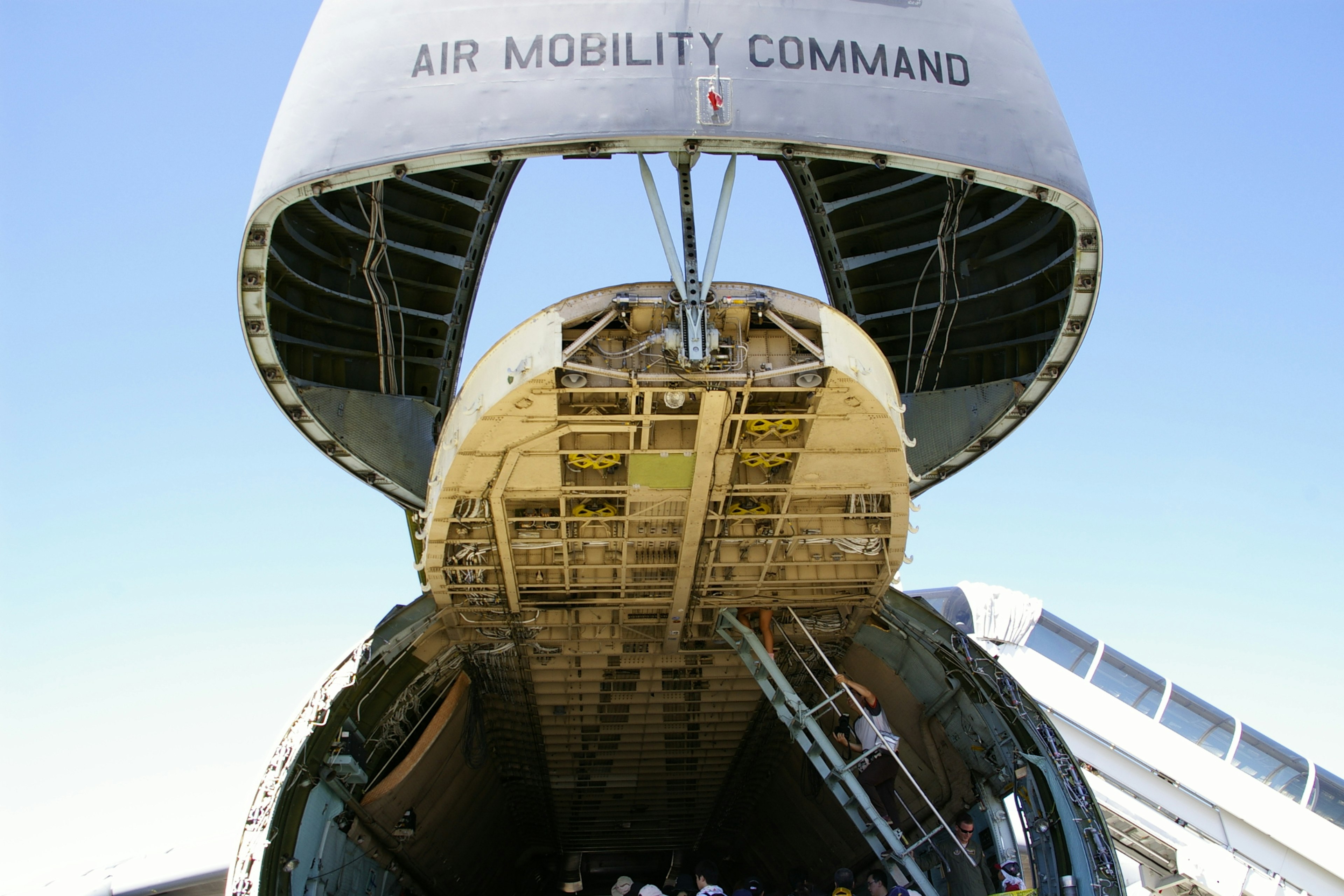 The cargo hold of an aircraft is open showcasing its internal structure and loading capacity