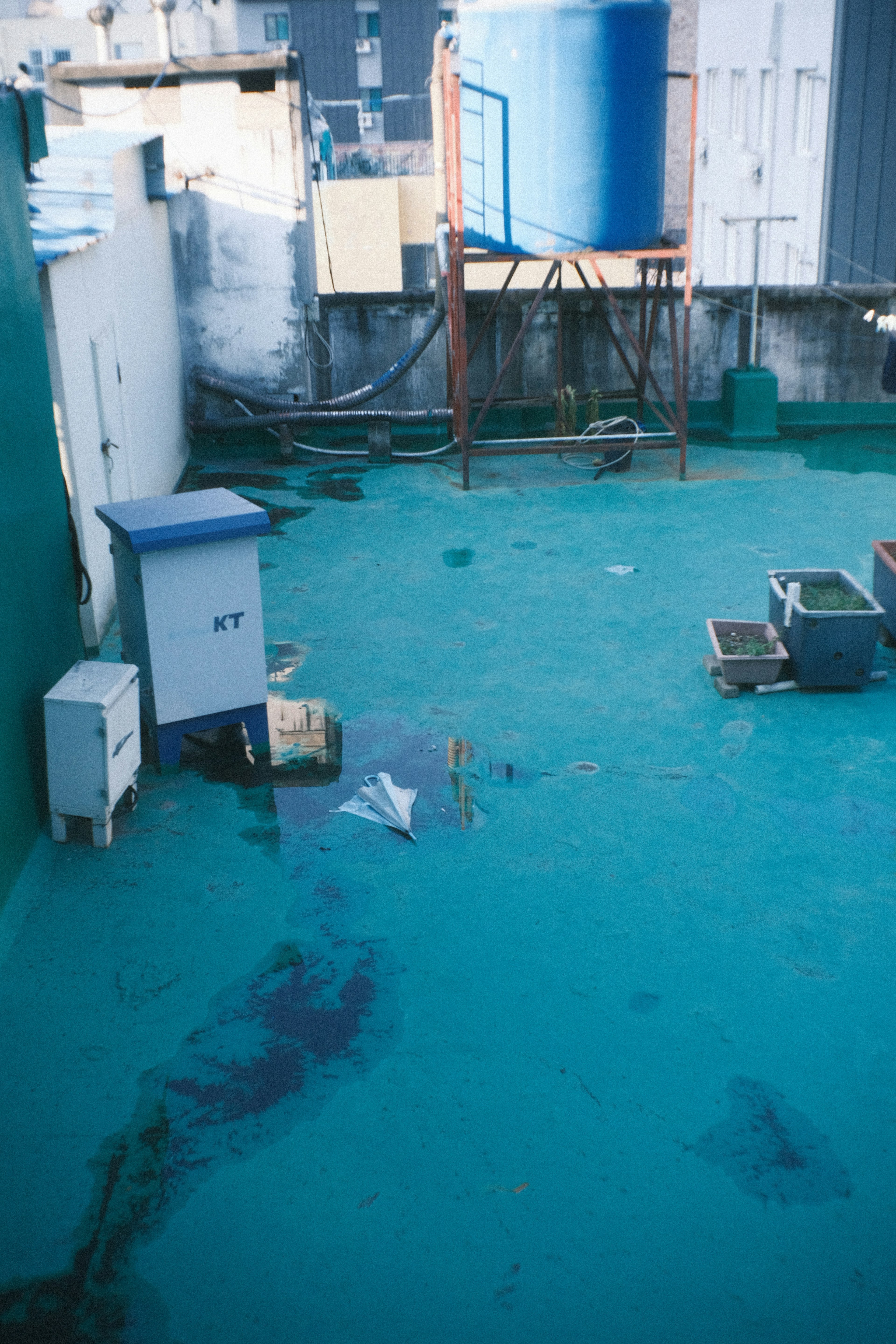 Toit avec un sol bleu présentant une boîte et un réservoir d'eau