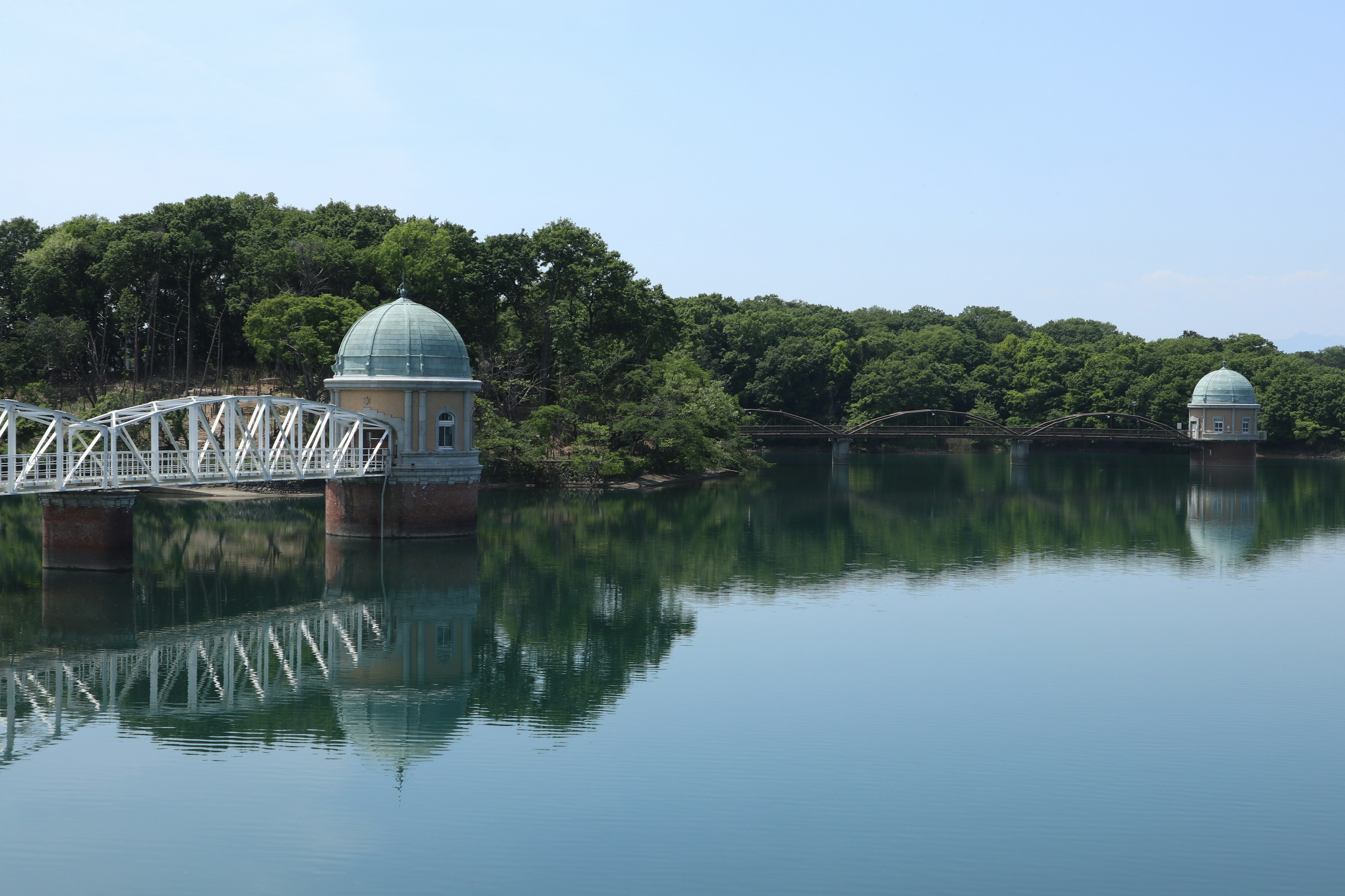 Vista panoramica di un ponte bianco e strutture a cupola su un lago tranquillo