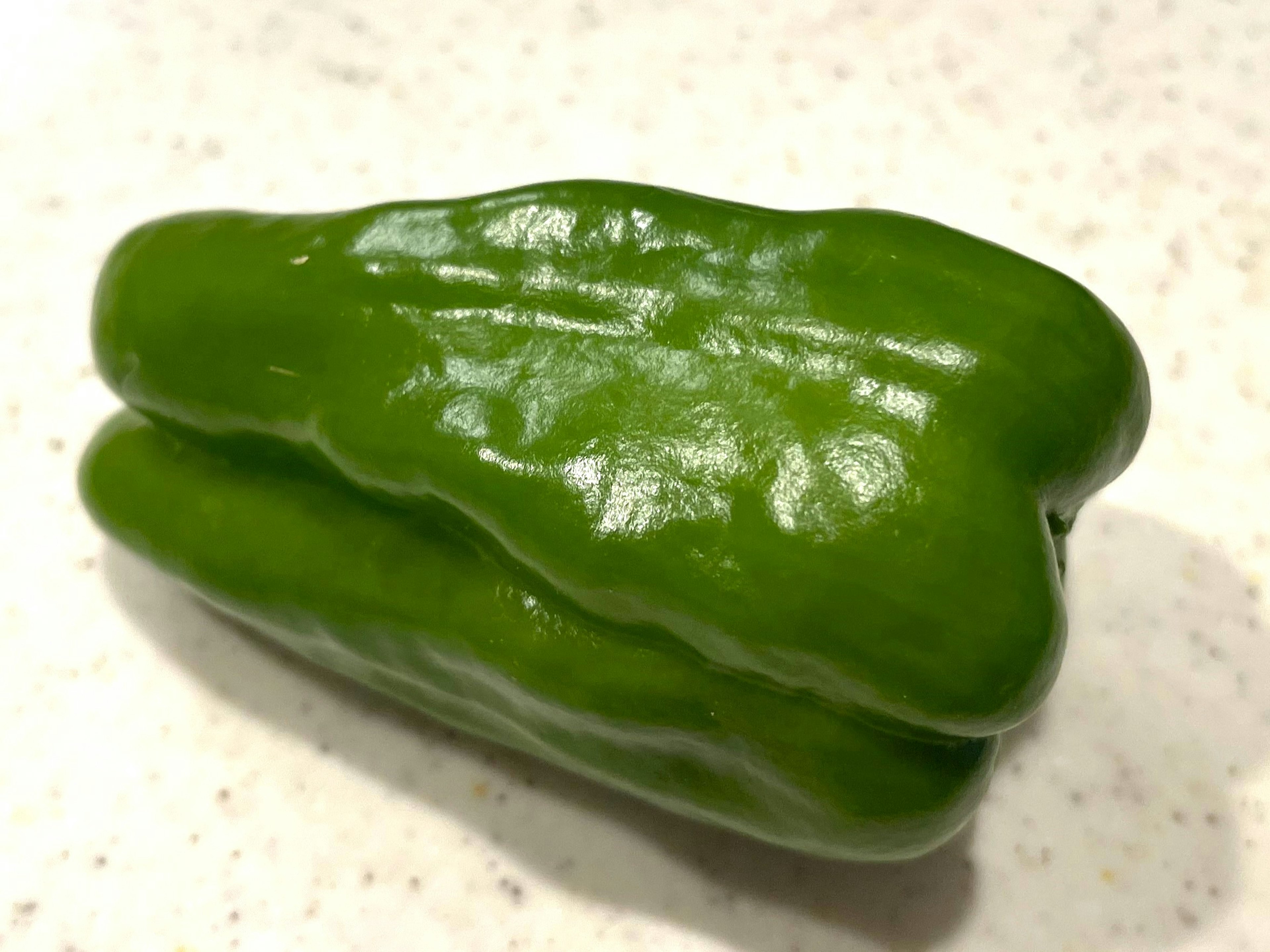 Forma única de un pimiento verde sobre un fondo claro