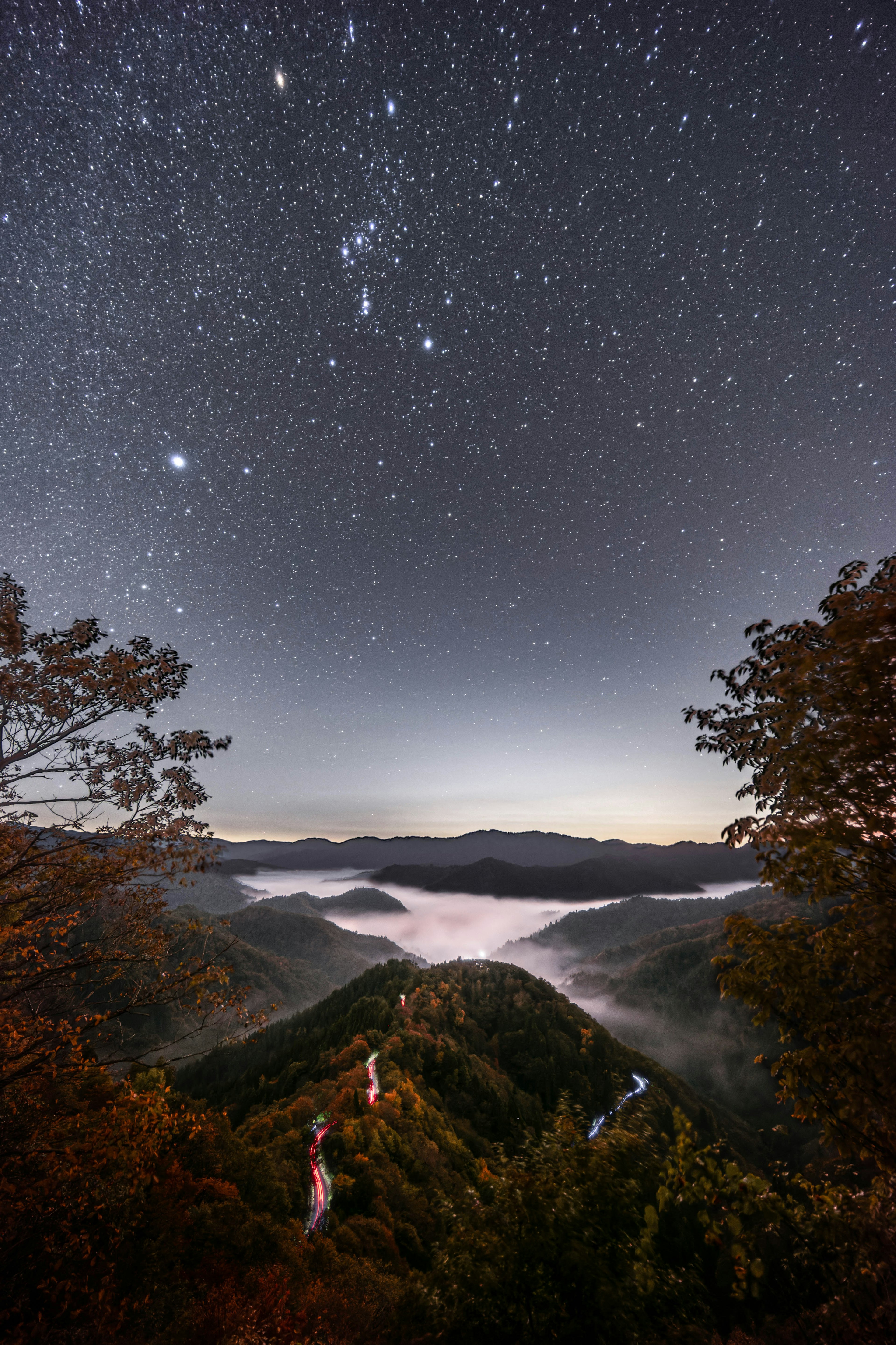 Vista panoramica delle montagne avvolte nella nebbia sotto un cielo stellato