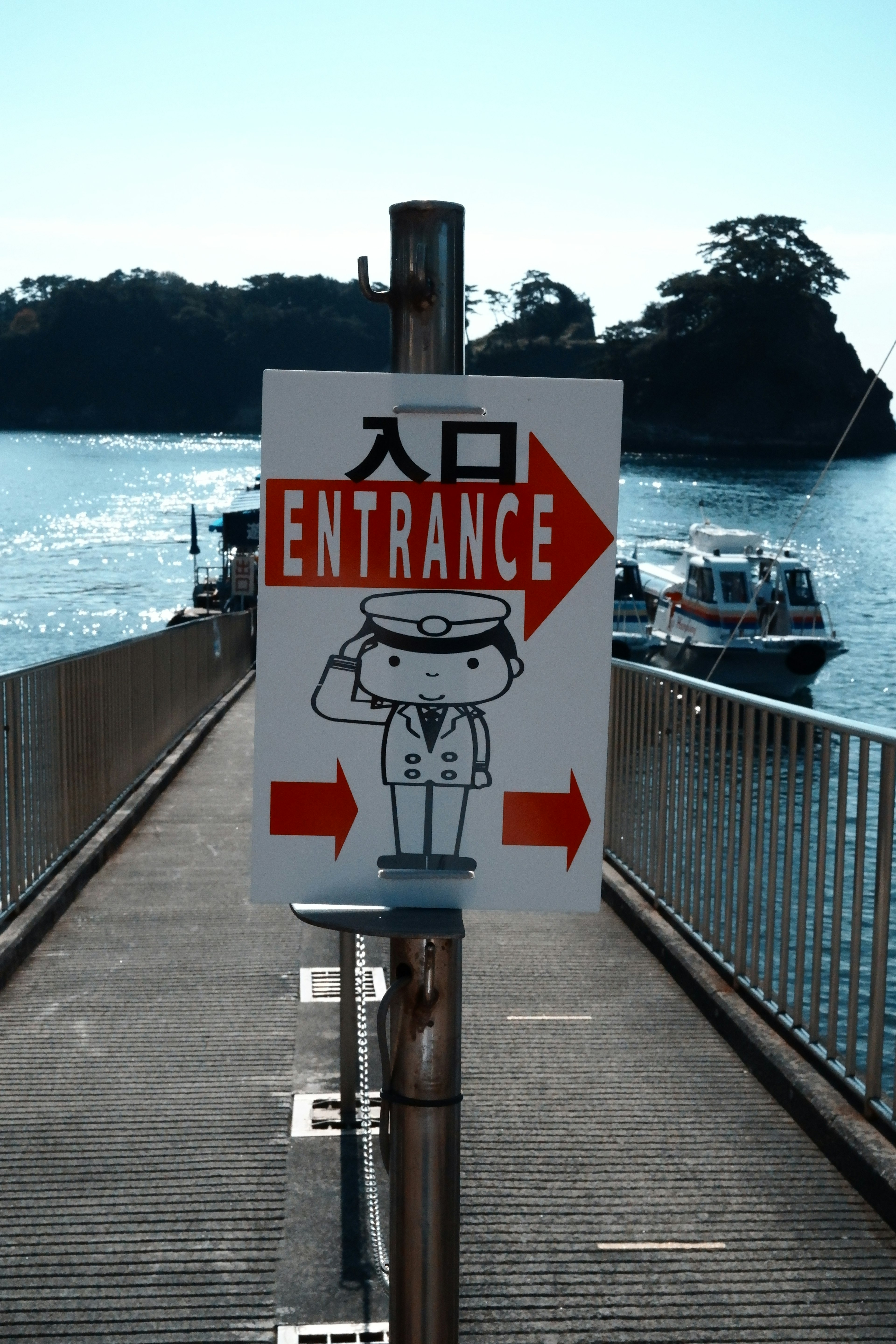 Sign indicating entrance with a cartoon character and ocean view