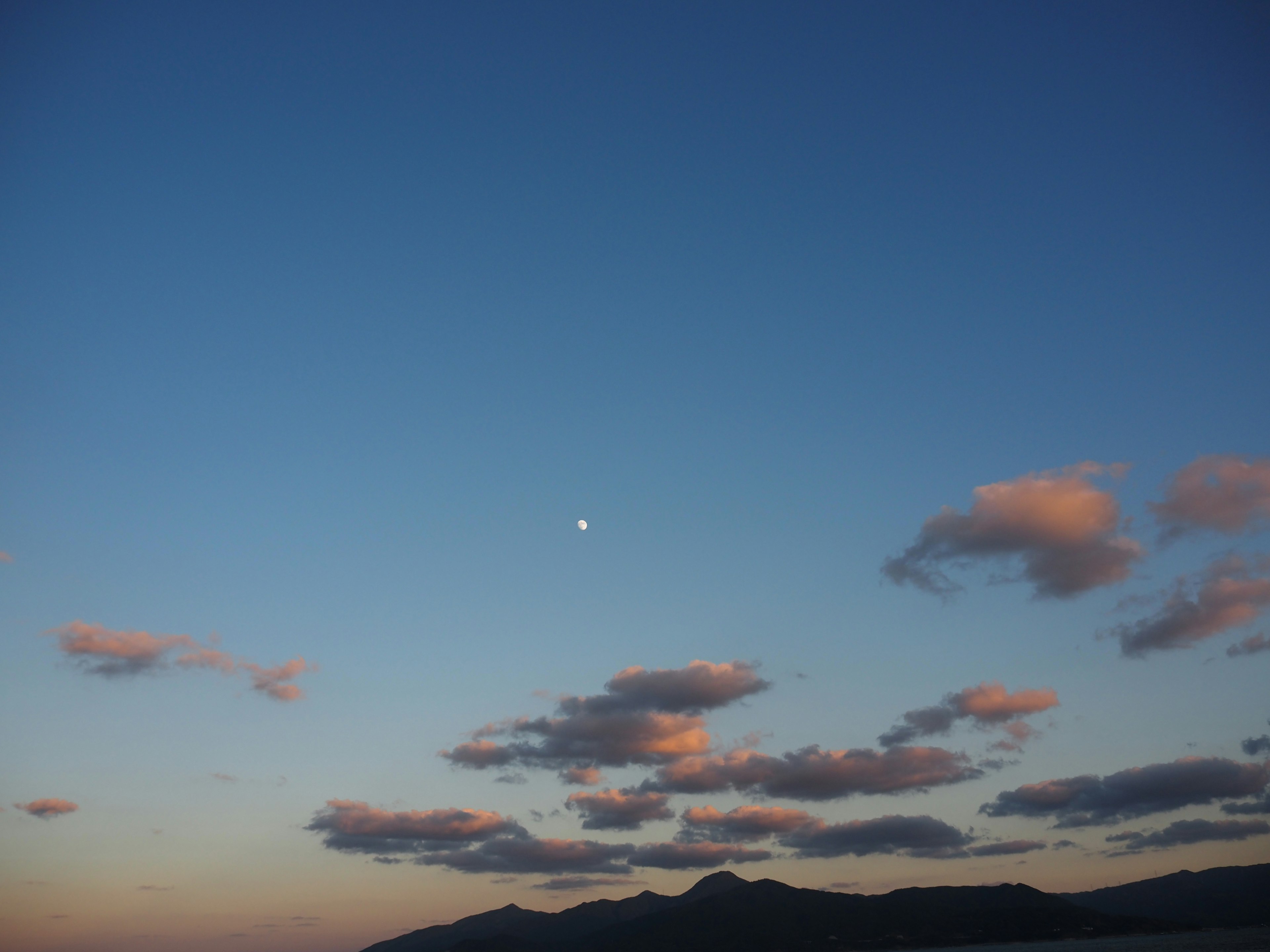 Paysage avec un croissant de lune dans un ciel bleu et des nuages doux