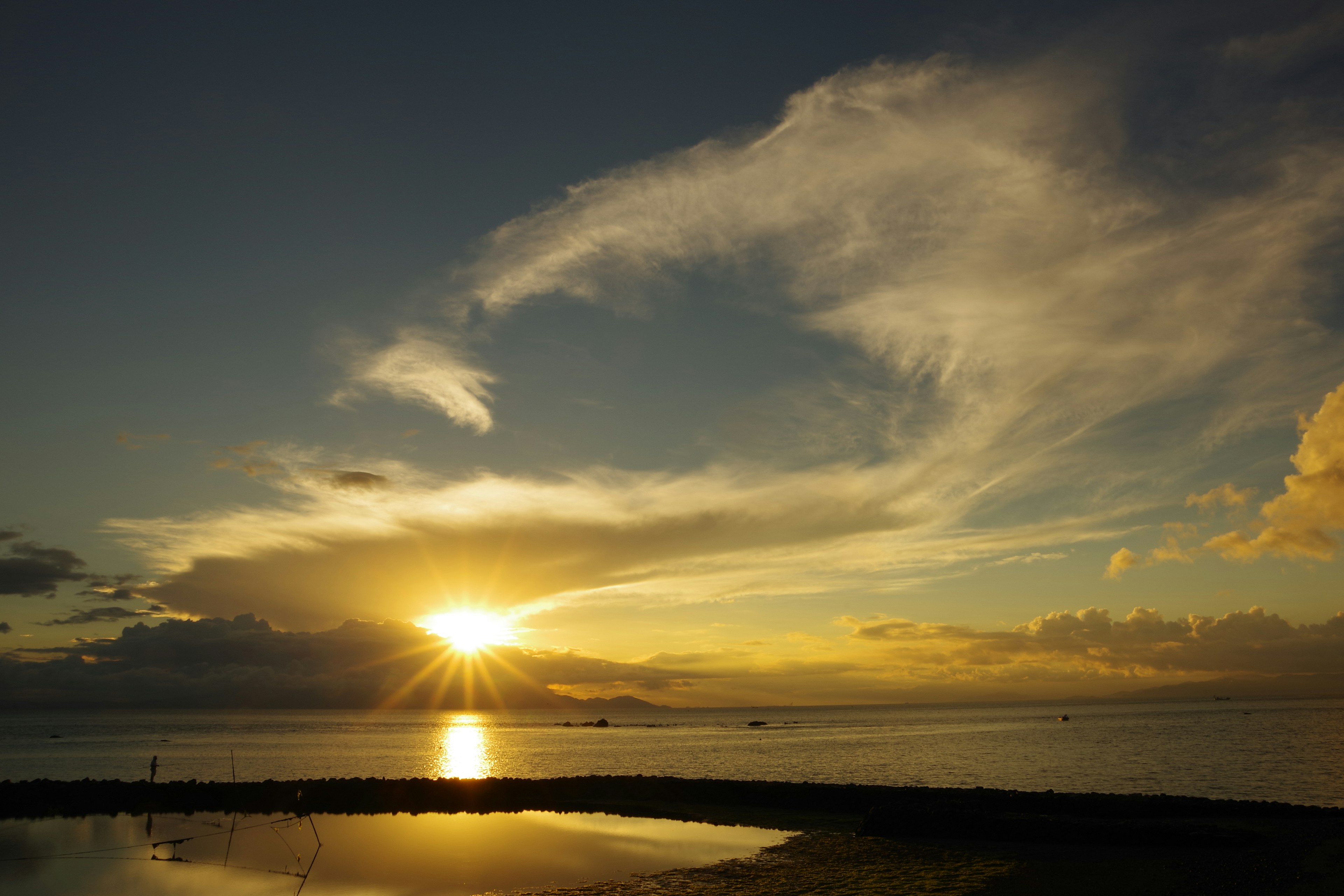 夕日が海に沈む美しい風景と雲の広がり